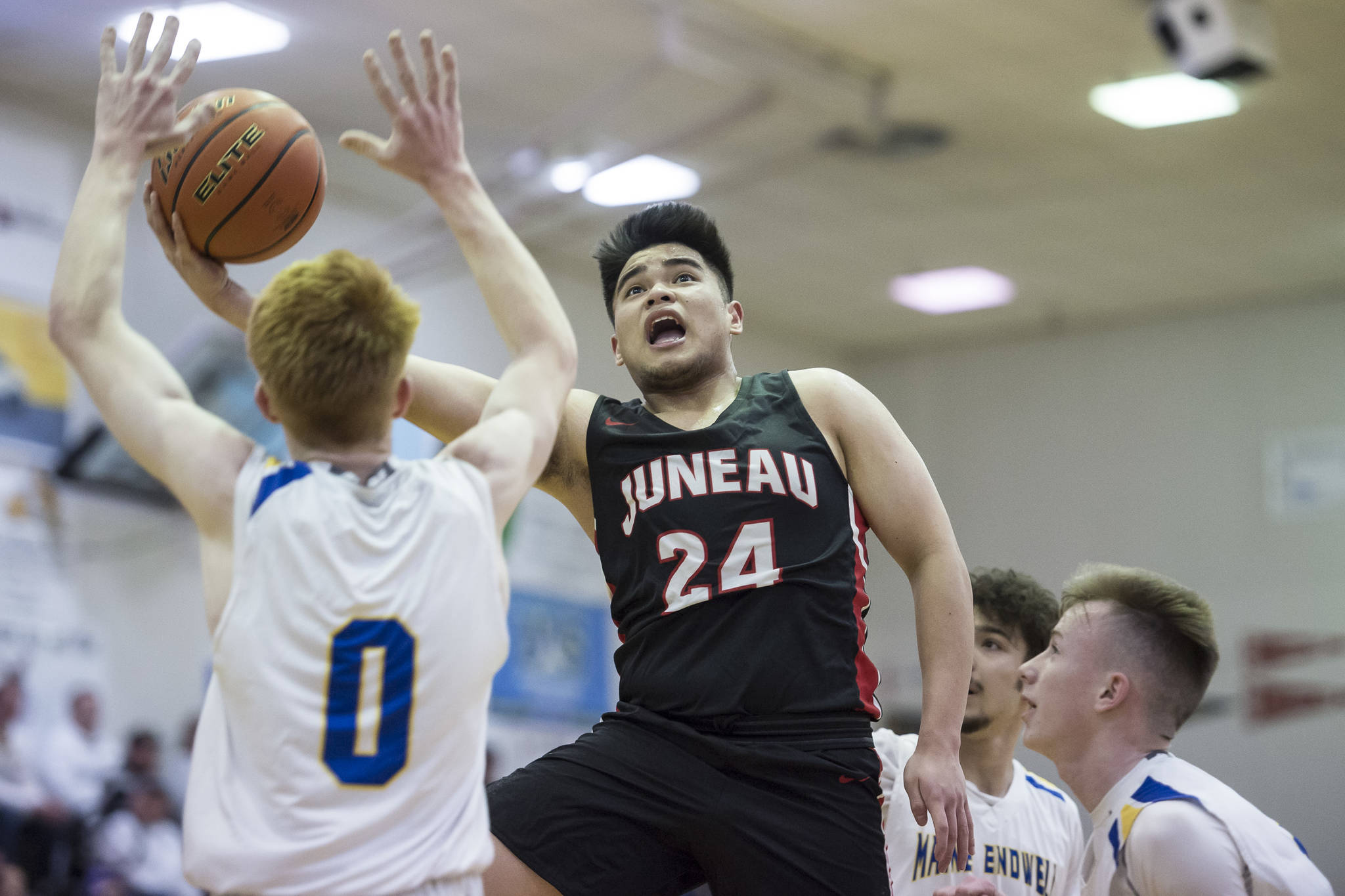 Juneau-Douglas’ Philip Gonzales, center, lays the ball up in front of Maine-Endwell’s Gannon Russell, left, at the Princess Cruises Capital City Classic at Juneau-Douglas High School on Saturday, Dec. 29, 2018. Juneau-Douglas won 66-61. (Michael Penn | Juneau Empire)