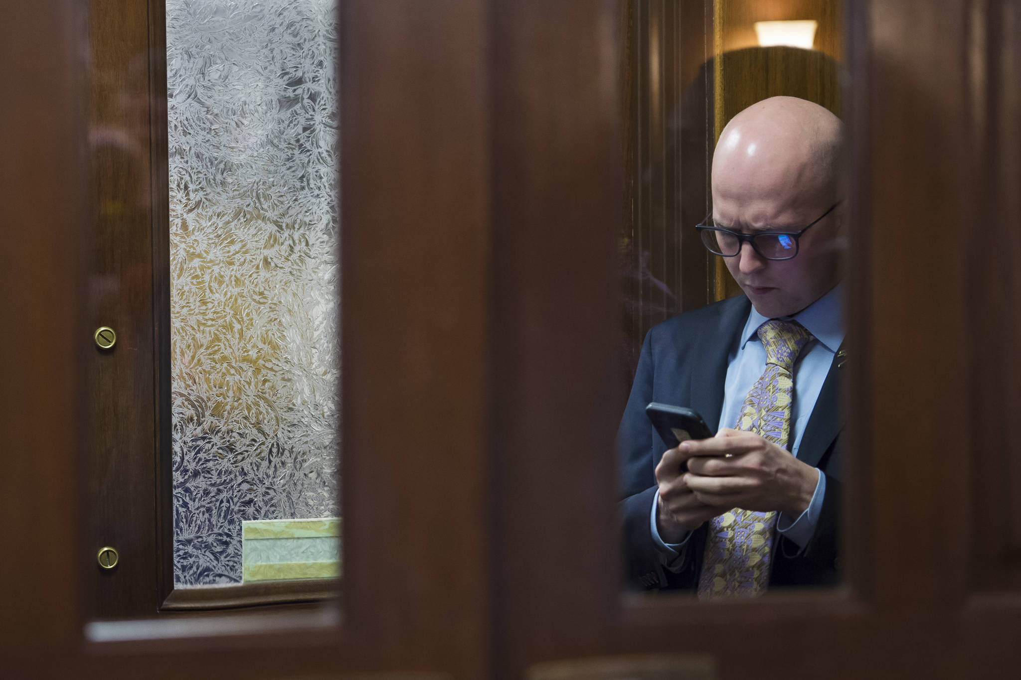 Rep. Jonathan Kreiss-Tomkins, D-Sitka, steps out of the House chambers to use his cell phone on the opening day of the 31st Session of the Alaska Legislature on Tuesday, Jan. 15, 2019. (Michael Penn | Juneau Empire)