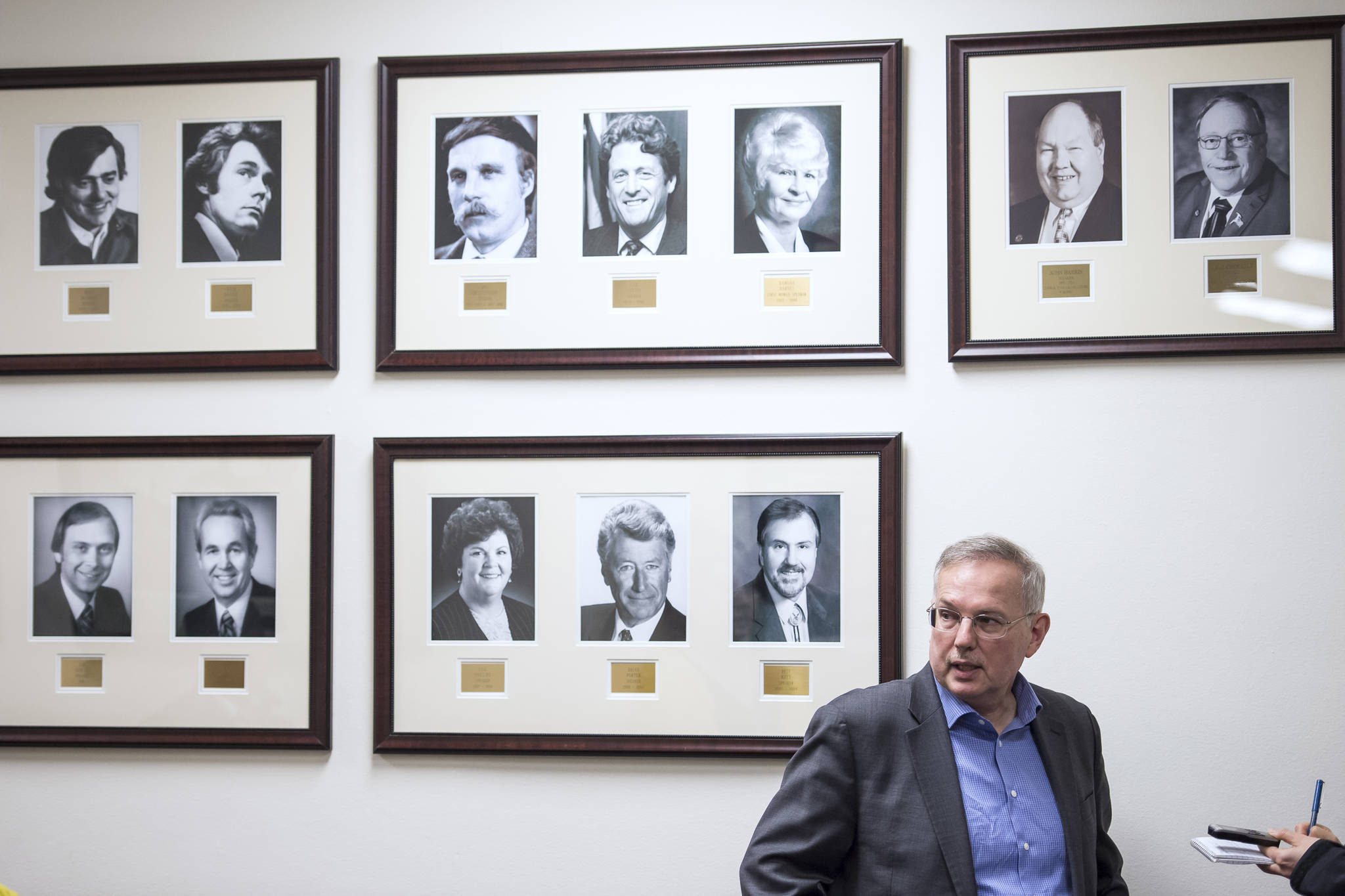 Former Speaker of the House Bryce Edgmon, D-Dillingham, is interviewed in front of pictures of former Speakers at the Capitol on Wednesday, Jan. 16, 2019. (Michael Penn | Juneau Empire)