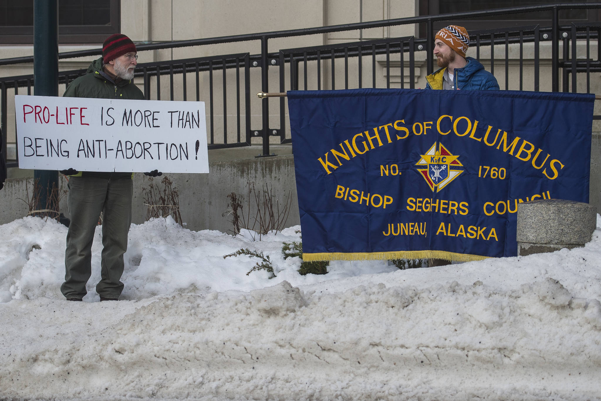 Paul Desloover, left, and Andrew Klausner hold their respective signs as Alaskans for Life, Inc. holds its annual Rally for Life in front of the Capitol on Tuesday, Jan. 22, 2019. (Michael Penn | Juneau Empire)