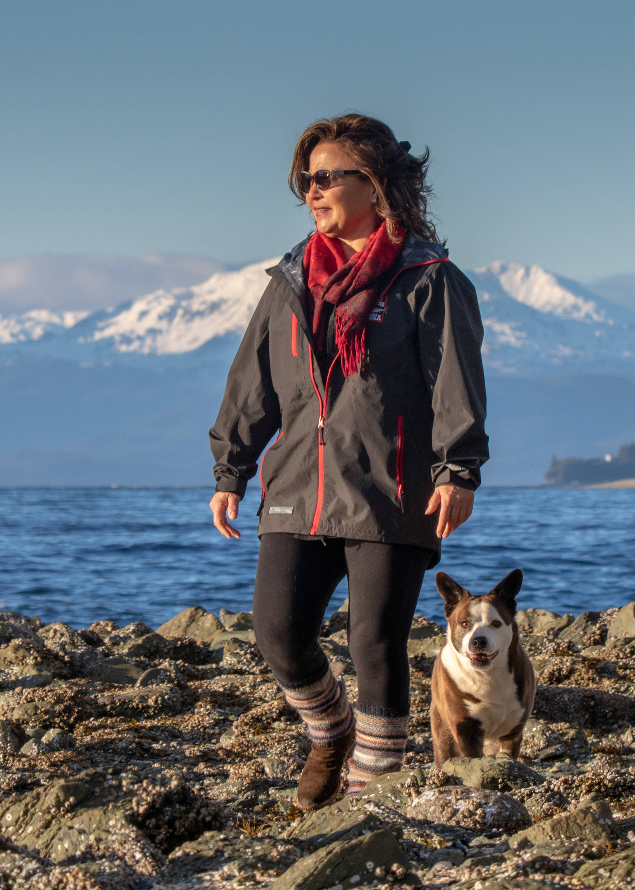 Dec. 2, 2018: There’s nothing better than a sunny day in November. Bonny Millard makes the most of it by taking a walk near Amalga Harbor. She dressed stylish and warm in a jacket from Taku Fisheries, black leggings from Athleta, multi-colored leg warmers, a red scarf and brown suede boots. Her best accessory? Her 13-year-old rescue dog McKenzie, who goes perfectly with everything she wears.