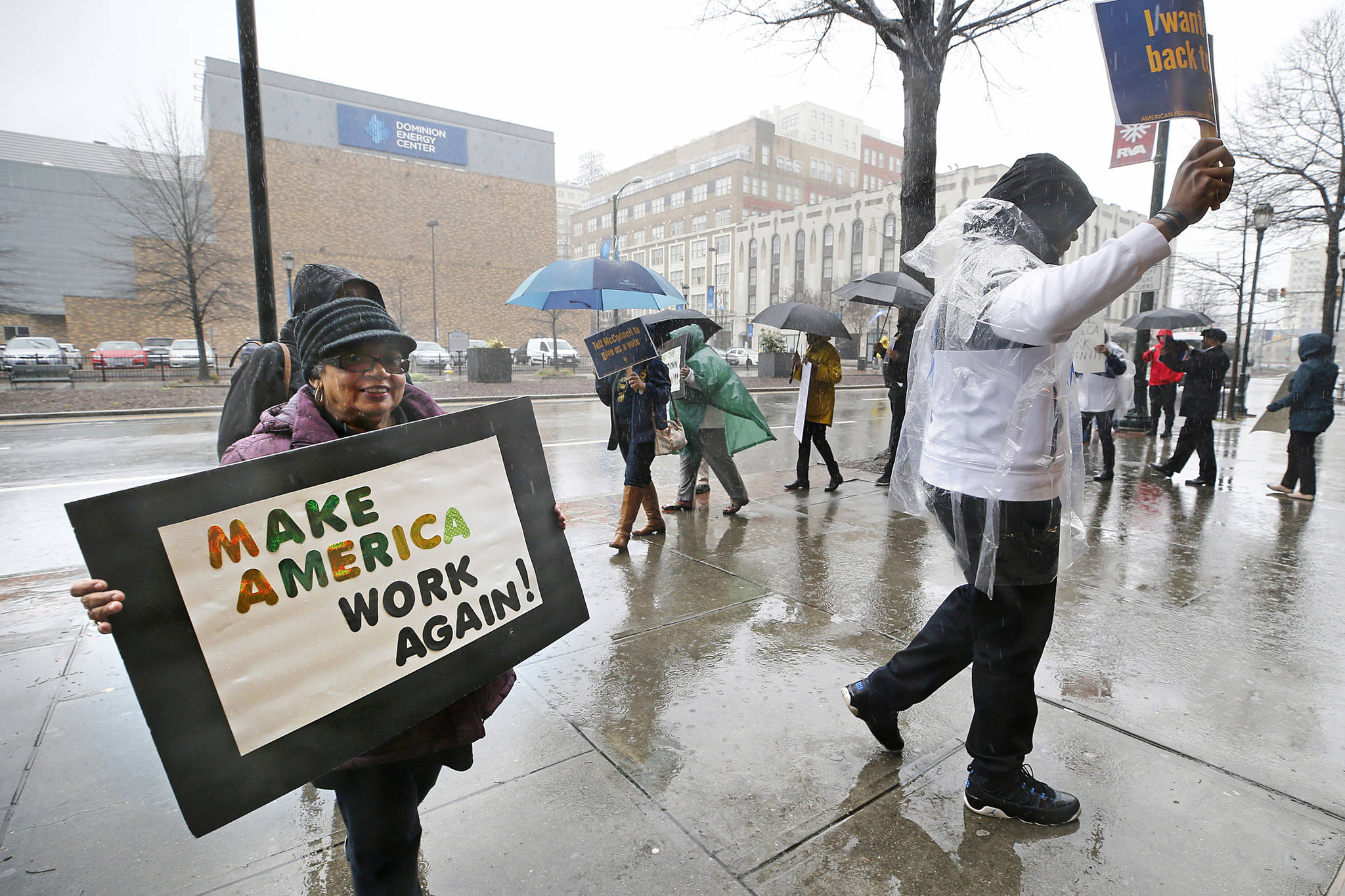 At left, Ann Taylor, HUD retiree and president of AFGE Local 3380, demonstrates to support The U.S. Department of Housing and Urban Development and Bureau of Prisons employees who are affected by the partial government shutdown Thursday, Jan. 24, 2019. (Alexa Welch Edlund | Richmond Times-Dispatch)