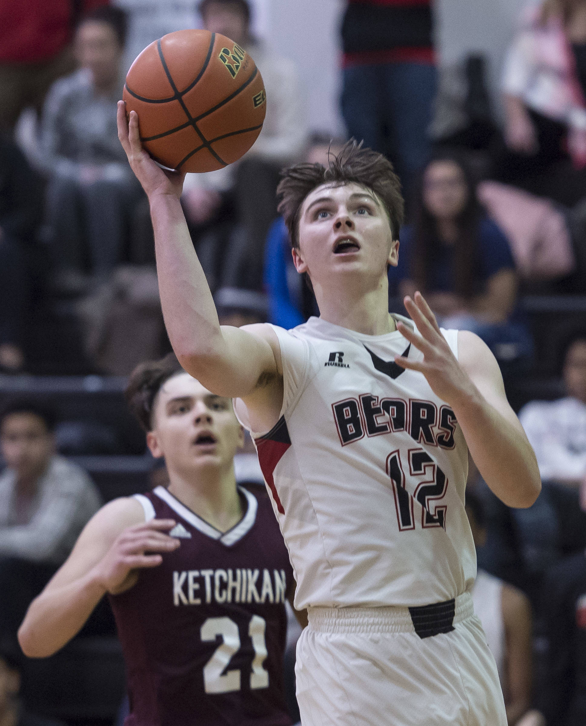 Juneau-Douglas Brock McCormick, right, lays the ball up against Ketchikans Kristian Pihl at JDHS on Friday, Jan. 11, 2019. JDHS won 75-67. (Michael Penn | Juneau Empire File)