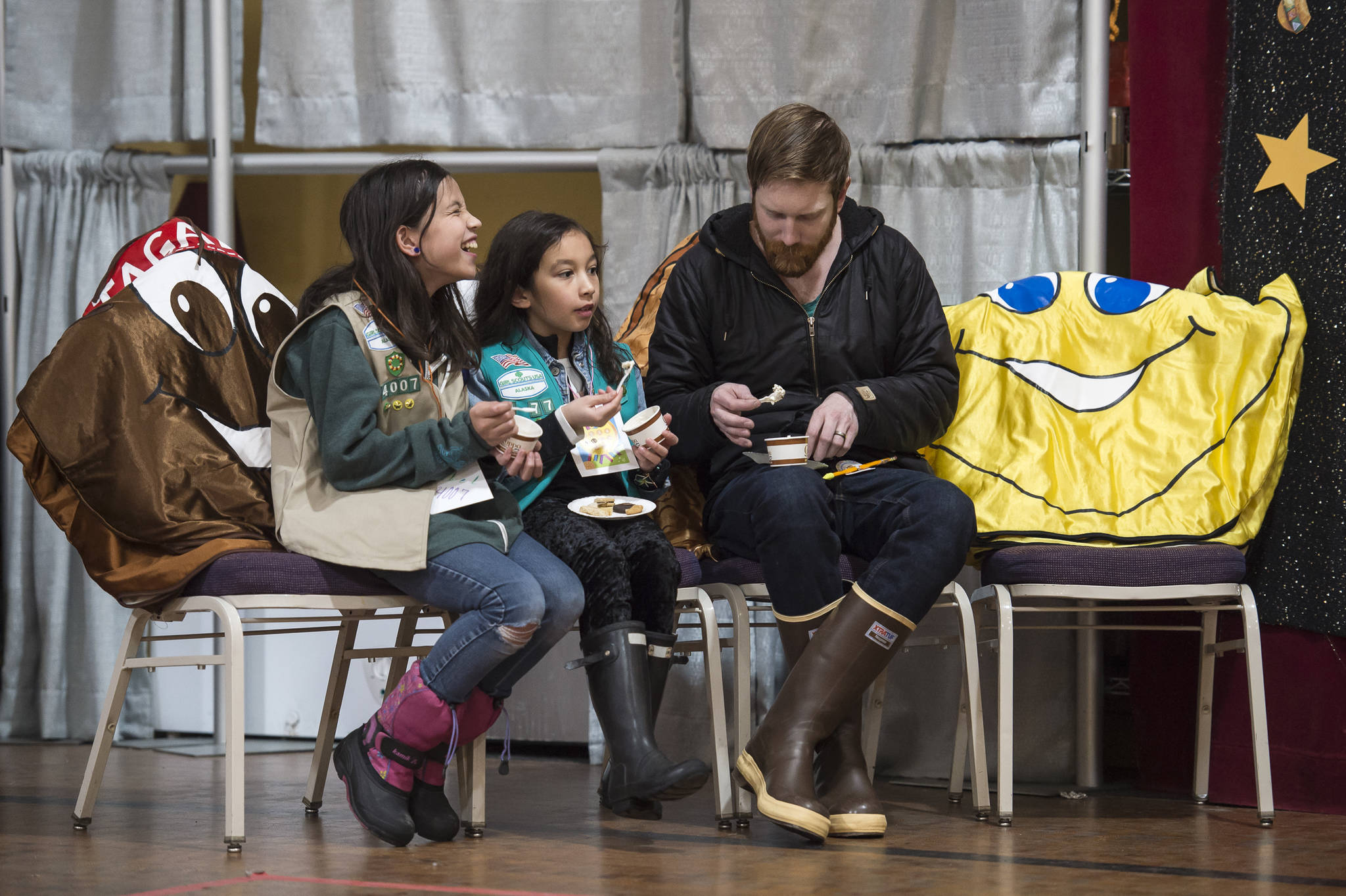 Jordan Kendall sits with his daughter, Neeka, 10, center, and Isabel Danner, 11, as they taste cookies and Coppa ice cream made with Girl Scout cookies during a Cookie Rally at the Juneau Arts & Culture Center on Friday, Jan. 11, 2019. The rally kicks off the first day of selling cookies for the Girl Scouts. (Michael Penn | Juneau Empire)