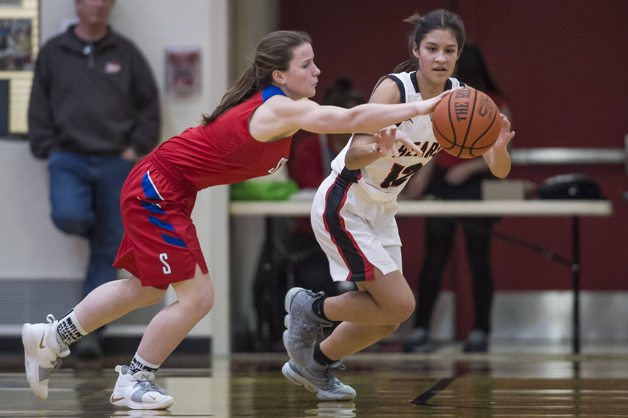 Juneau-Douglas’ Trinity Jackson, right, attempts a steal against Sitka’s Tawny Smith at JDHS on Friday, Jan. 25, 2019. Sitka won 37-31. (Michael Penn | Juneau Empire)