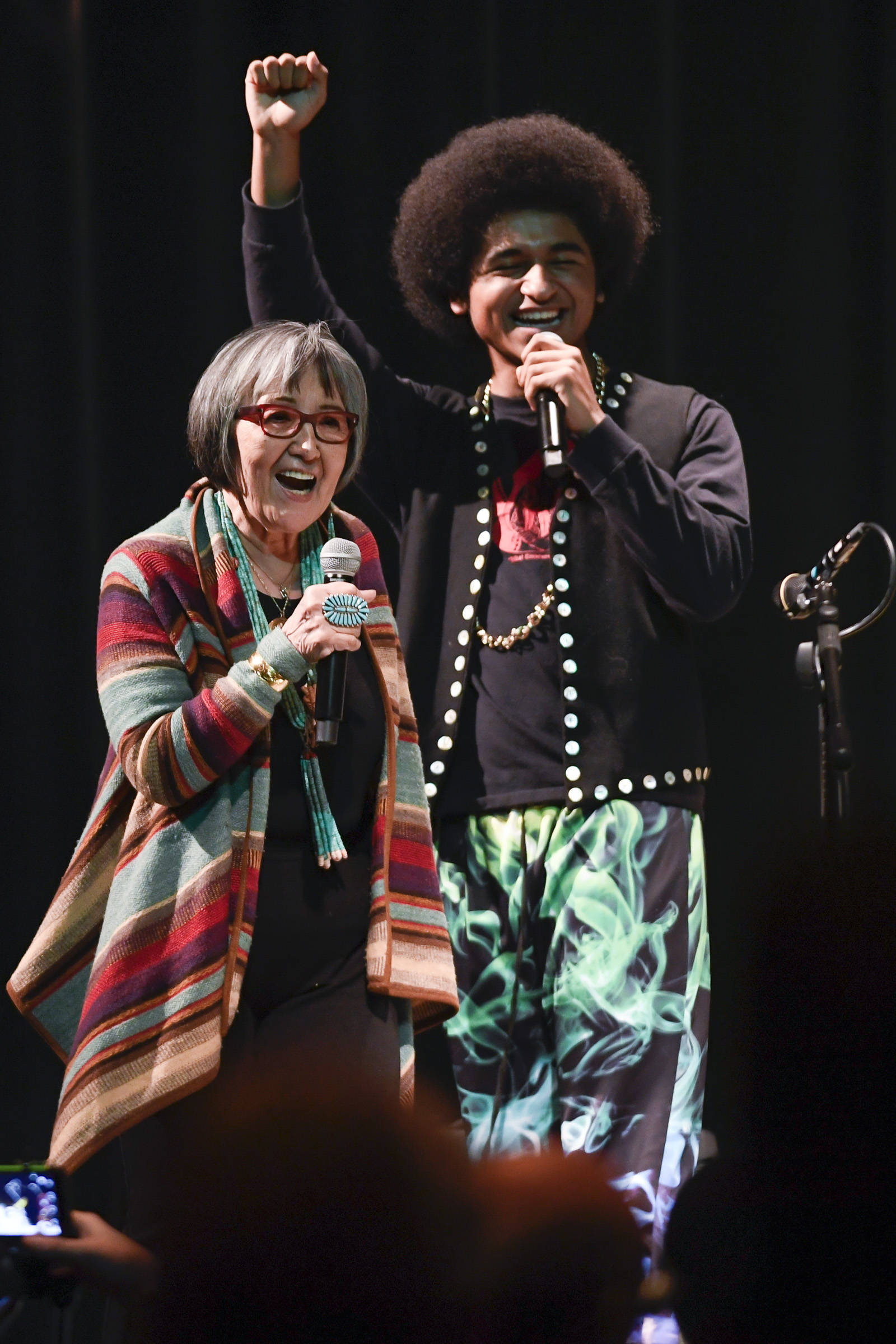 Rosita Worl, president of the Sealaska Heritage Institute, celebrates the perfomance of Hip Hop duo of Arias “A.J.” Hoyle, right, and Chris Talley as an opening act before Khu.eex’ performance at Centennial Hall on Monday, Jan. 28, 2019. (Michael Penn | Juneau Empire)