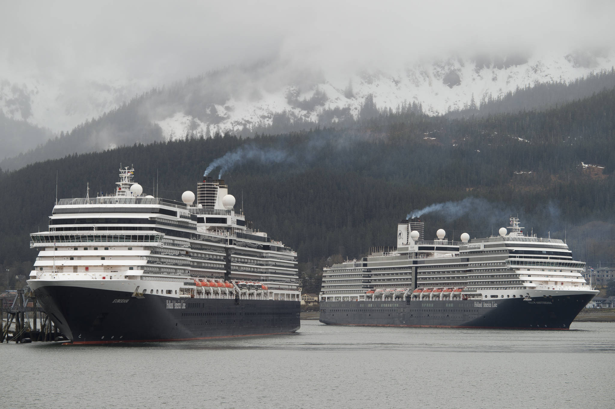 The Holland America Line cruise ships Eurodam, left, and Nieuw Amsterdam pull into Juneau’s downtown harbor on May 1, 2017. (Michael Penn | Juneau Empire)