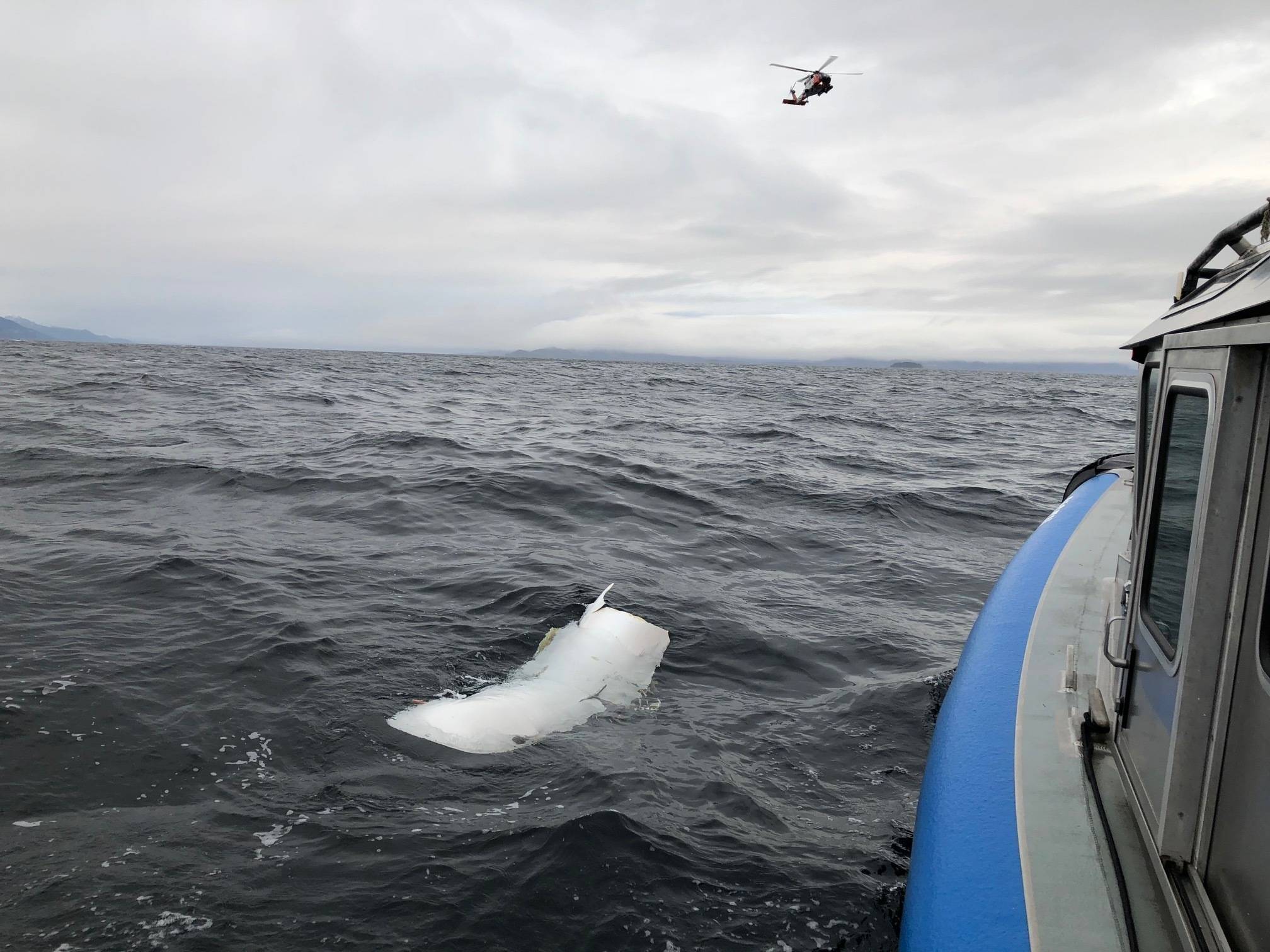 A Coast Guard Air Station Sitka MH-60 Jayhawk helicopter crew flies over a piece of debris spotted by Alaska Wildlife Troopers while searching for three people aboard an overdue Guardian Life Flight aircraft 20-miles west of Kake, Alaska, Jan. 30, 2019. Coast Guard Cutters Anacapa and Bailey Barco, along with an Alaska Army National Guard, several search and rescue teams and good Samaritans began searching for the aircraft and three people aboard after it did not arrive as scheduled to Kake Jan. 29, 2019, to retrieve a patient for transport. (Photo courtesy of Alaska Wildlife Troopers)