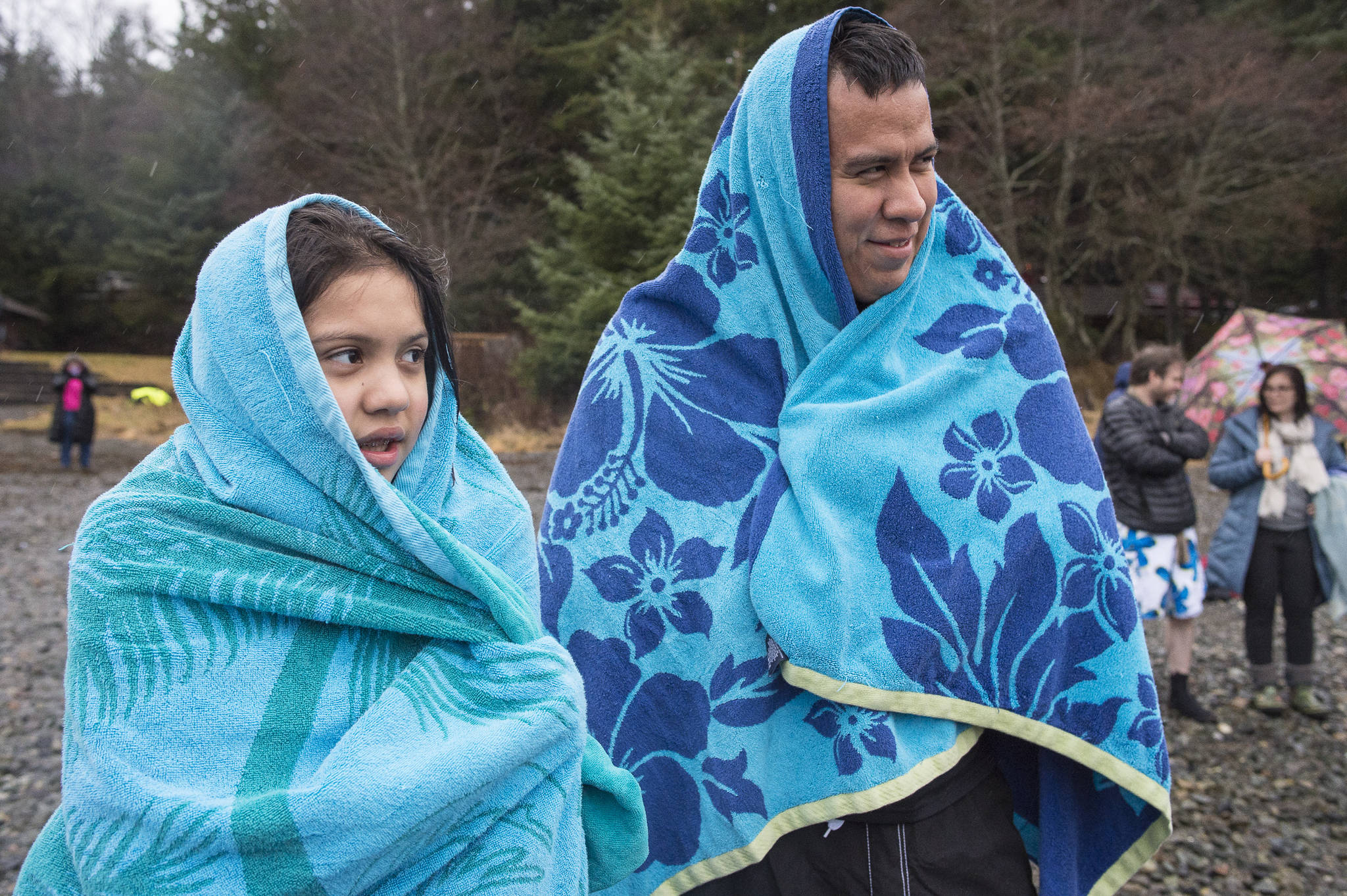 Shawn Jackson and his daughter, Sarah, 10, cover up in towels before taking to the frigid waters at Auke Bay Recreation Area for the annual Juneau Polar Bear Dip on Tuesday, Jan. 1, 2019. Nearly 200 people took the plunge to start off the new year. (Michael Penn | Juneau Empire)