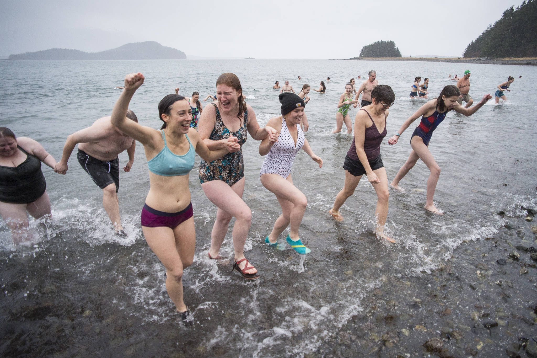 Juneau residents return from the frigid waters at Auke Bay Recreation Area for the annual Juneau Polar Bear Dip on Tuesday, Jan. 1, 2019. Nearly 200 people took the plunge to start off the new year. (Michael Penn | Juneau Empire)