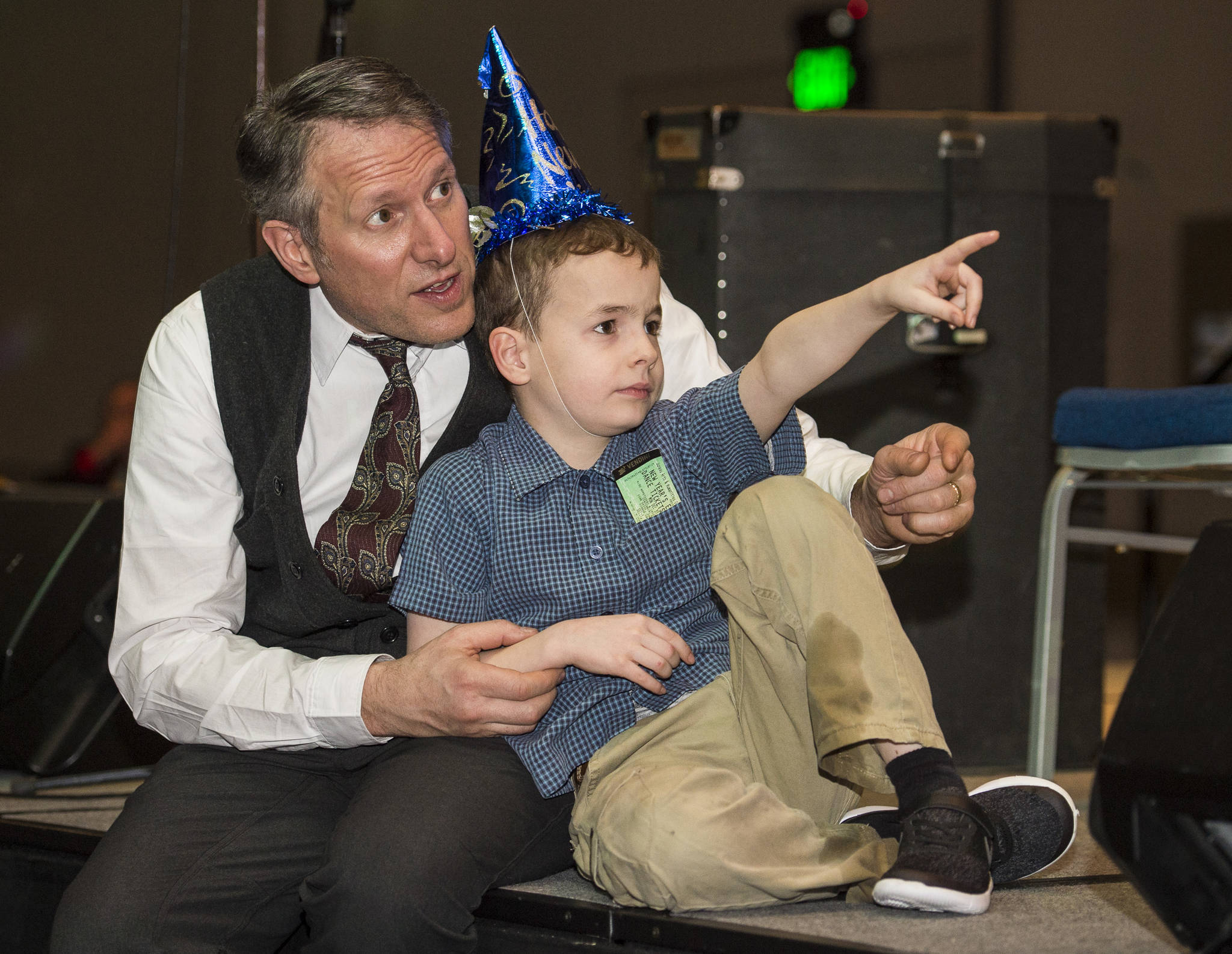 Sean Boily watches the activities with his son, Axel, 9, at the New Year’s Eve Gala at Centennial Hall on Monday, Dec. 31, 2018. The event was a fundraiser for the Juneau Arts and Humanities Council and Juneau Jazz & Classics. (Michael Penn | Juneau Empire)