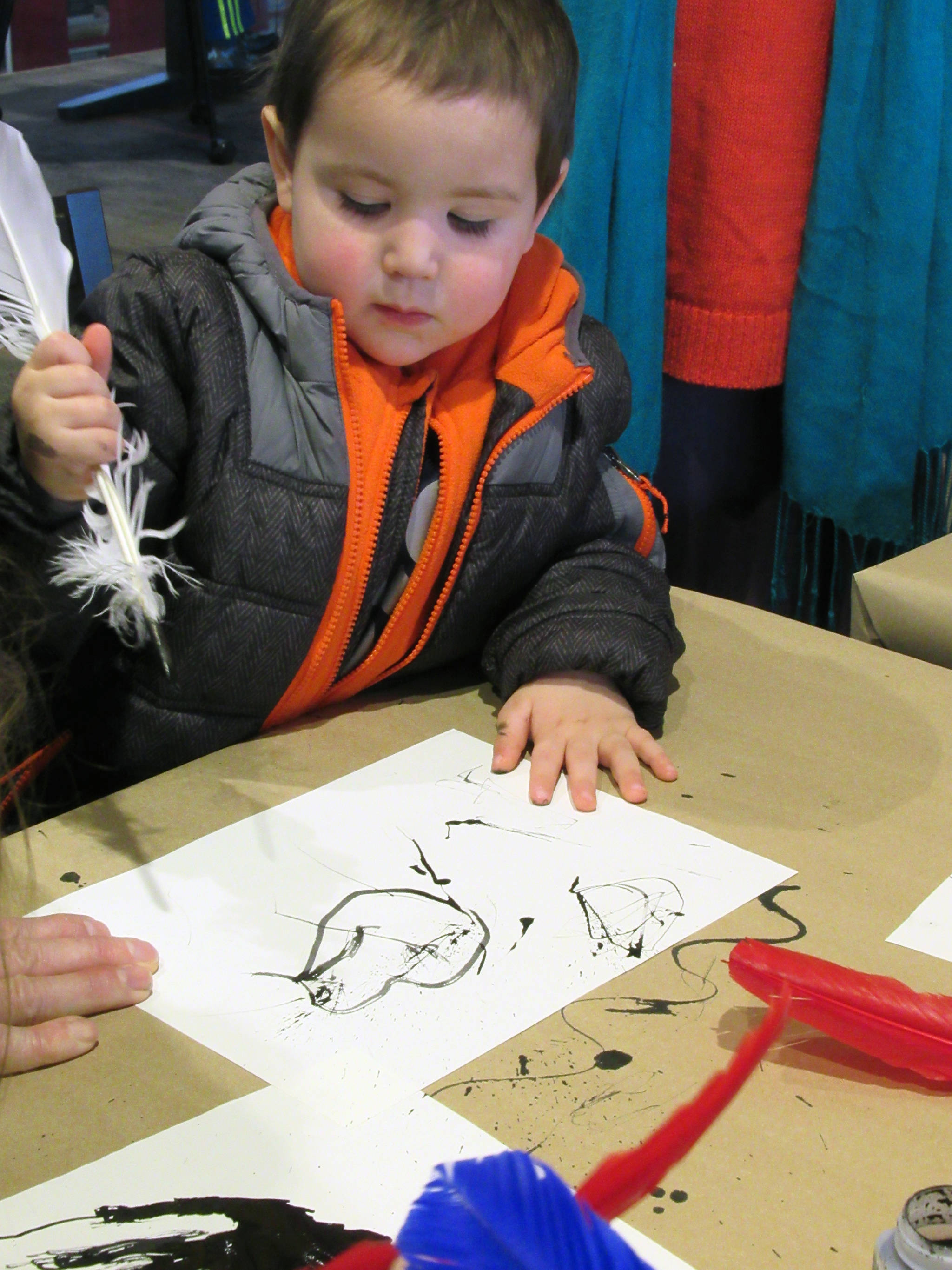 Raymond Howard, 2, tries writing with a quill during the Family Fair Friday, Jan.4, 2019. (Ben Hohenstatt | Capital City Weekly)