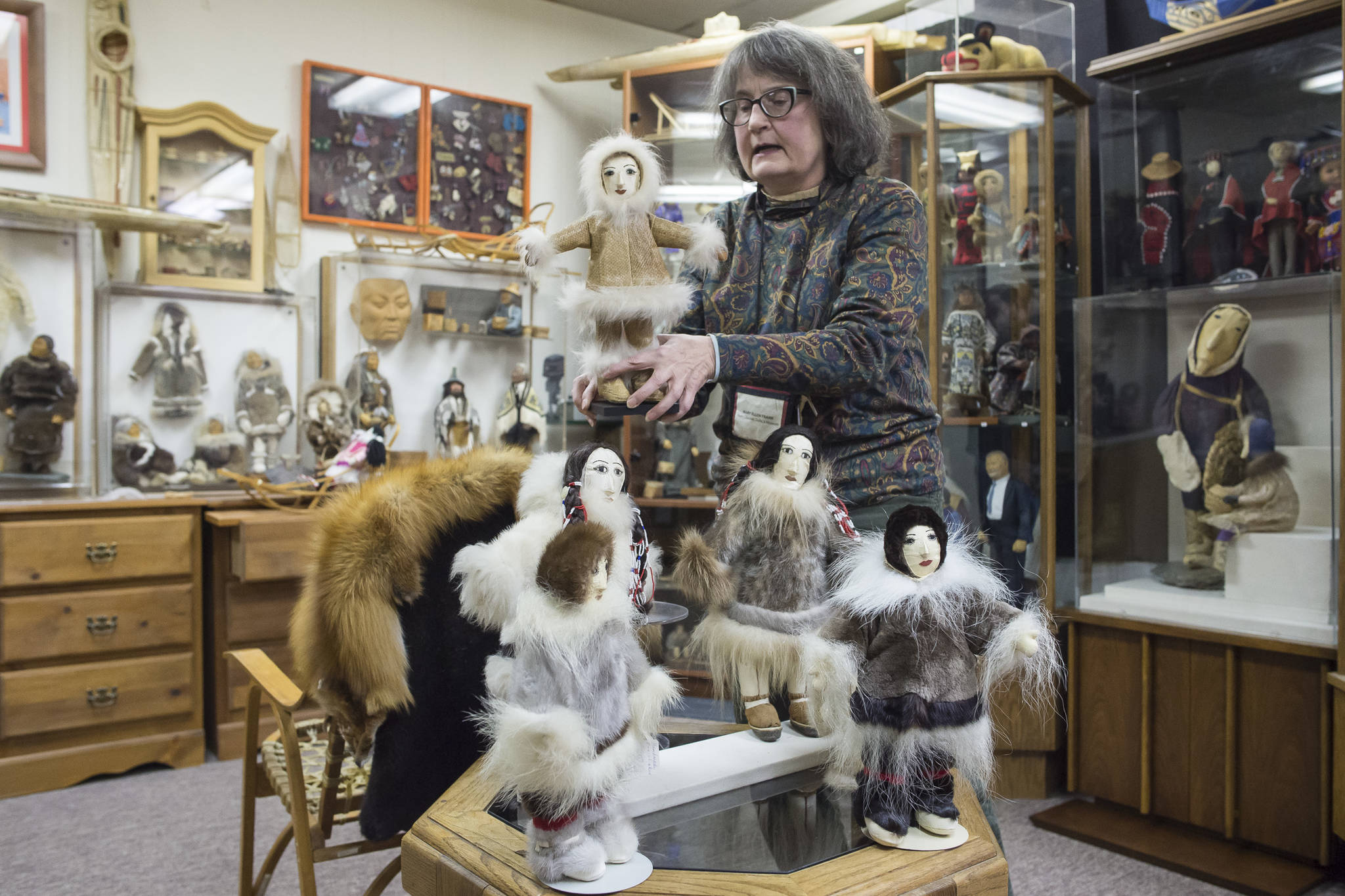 Mary Ellen Frank shows off the work of Saint Lawrence Island artist Anacoma Slwooko at Aunt Claudia’s Doll Museum during First Friday on Friday, Jan. 4, 2019. (Michael Penn | Juneau Empire)
