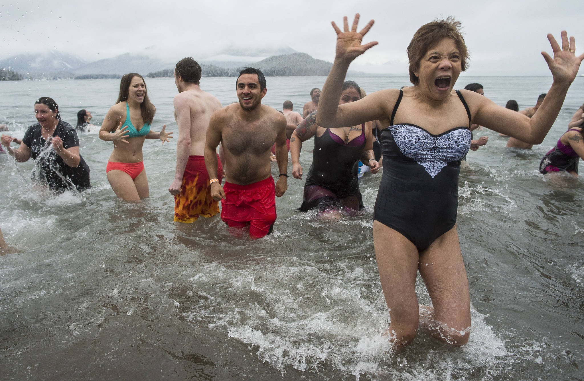 Juneau residents react to the 37 degree water temperature during the annual Polar Bear Dip at Auke Recreation beach on Monday, Jan. 1, 2018.
