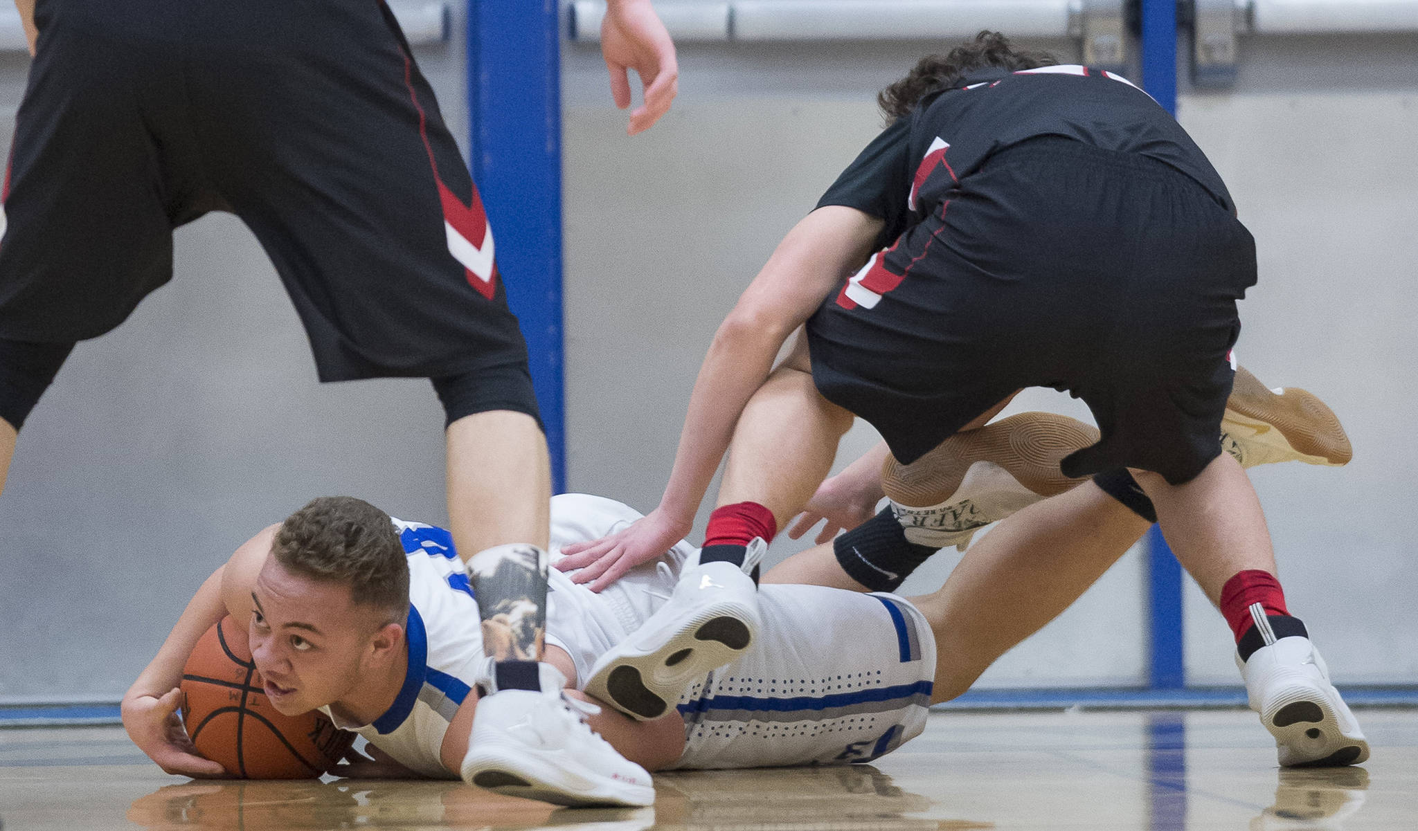 Thunder Mountain’s Vaipuna Toutaiolepo dives for a loose ball against Juneau-Douglas’ Cooper Kriegmont during their game at TMHS on Friday, Jan. 5, 2017. TMHS won 50-45.
