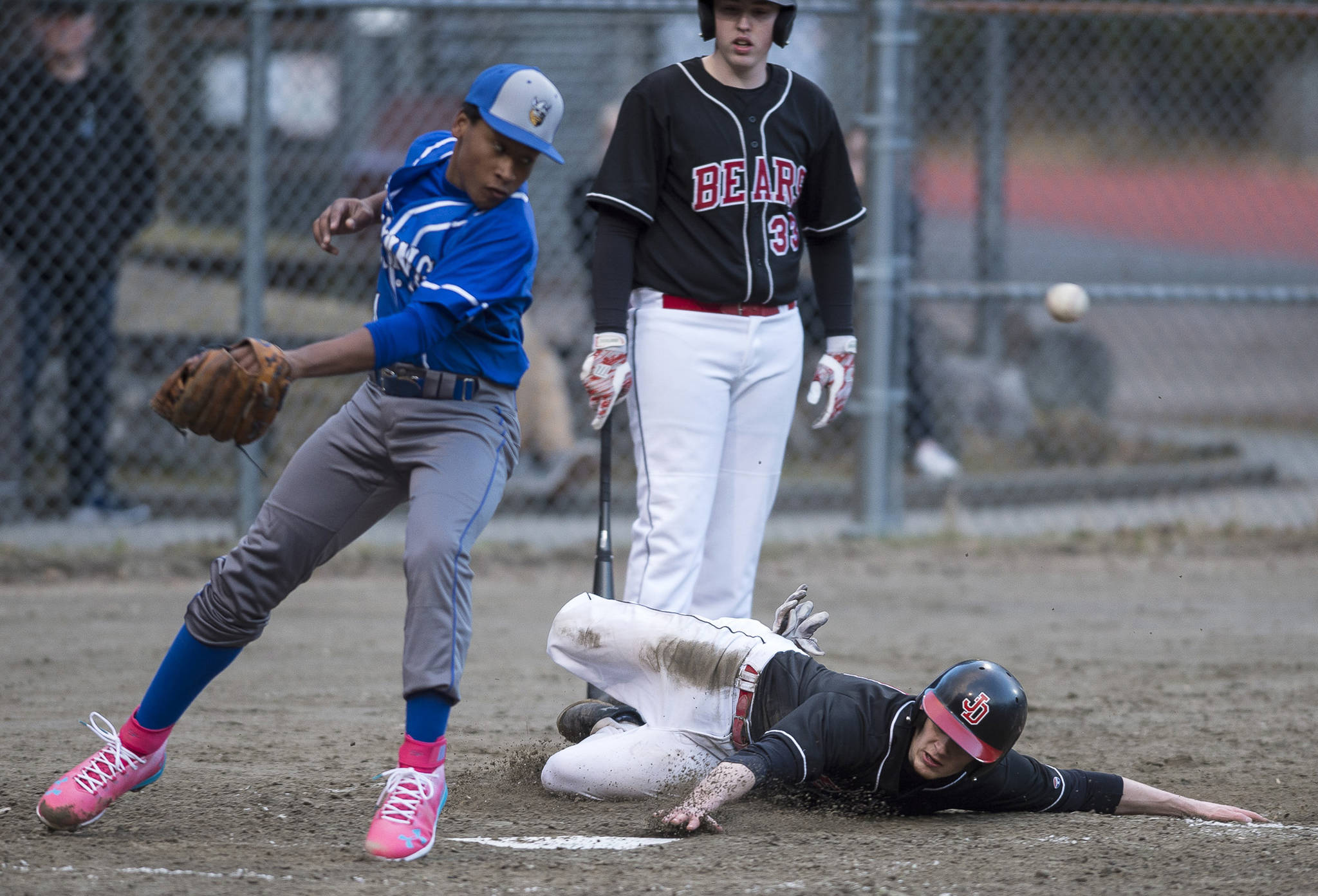 Juneau-Douglas’ Jacob Dale slides to steal home and score as Petersburg’s Sawyer Bryner misses the throw at Adair-Kennedy Memorial Park on Friday, April 27, 2018. (Michael Penn | Juneau Empire)