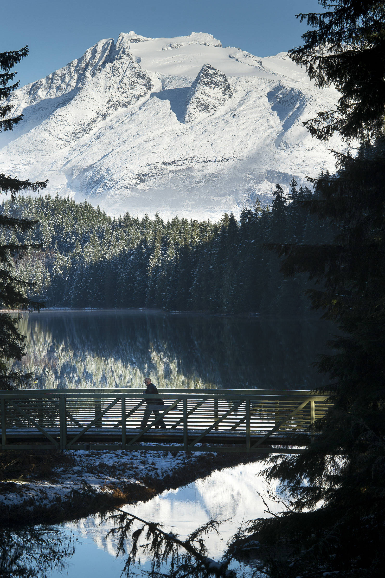 A pedestrian crosses the bridge at Auke Lake on Monday, Nov. 5, 2018. The National Weather Service forecasts clear skies through Wednesday with highs in the upper 30s. (Michael Penn | Juneau Empire)