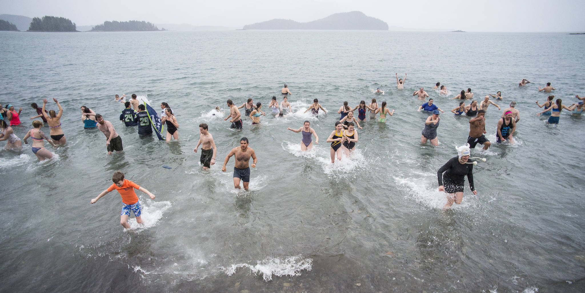 Juneau residents take to the frigid waters at Auke Bay Recreation Area for the annual Juneau Polar Bear Dip on Tuesday, Jan. 1, 2019. Nearly 200 people took the plunge to start off the new year. (Michael Penn | Juneau Empire)