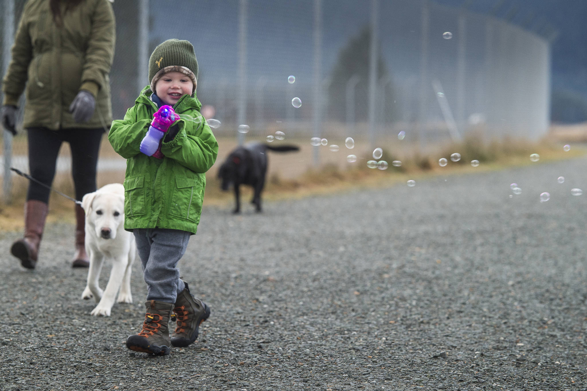 Otis Ward, 3, fires off his soap bubble gun while on a walk with his parents, Mike and Jessalyn, along the Airport Dike Trail on Wednesday, Jan. 2, 2019. (Michael Penn | Juneau Empire)