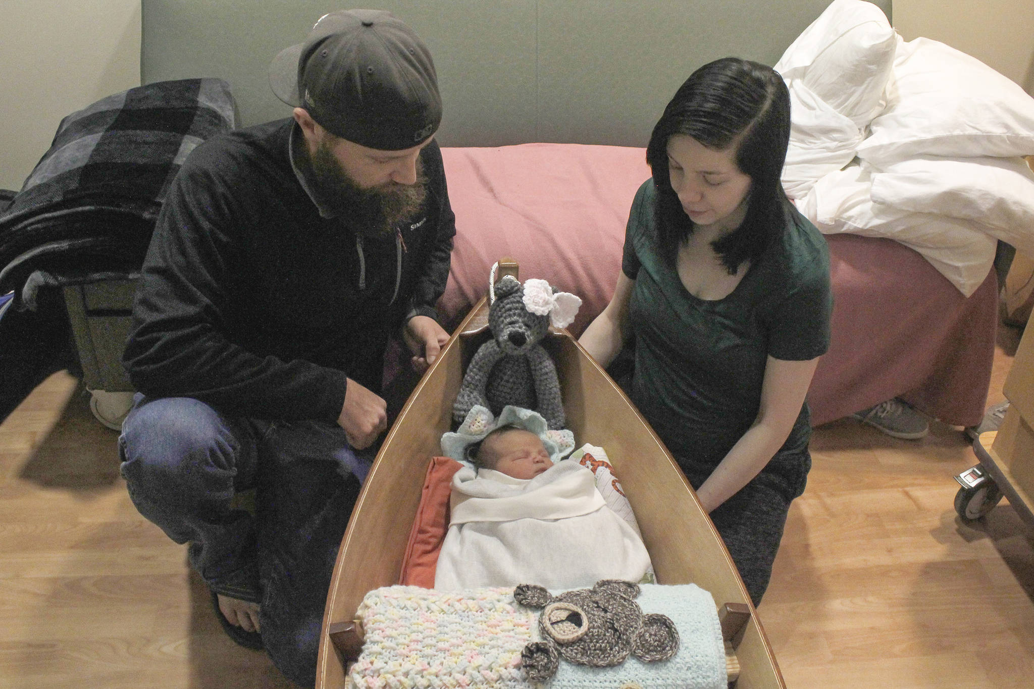 Yakutat residents Cody Kunau and Samantha Munoz sit with their baby Saige Roisin Kuneau on Friday, Jan. 4 at Bartlett Regional Hospital. Saige was the first baby born at the hospital this year, and received a boat carved by BRH Emergency Room Dr. Lindy Jones. (Alex McCarthy | Juneau Empire)