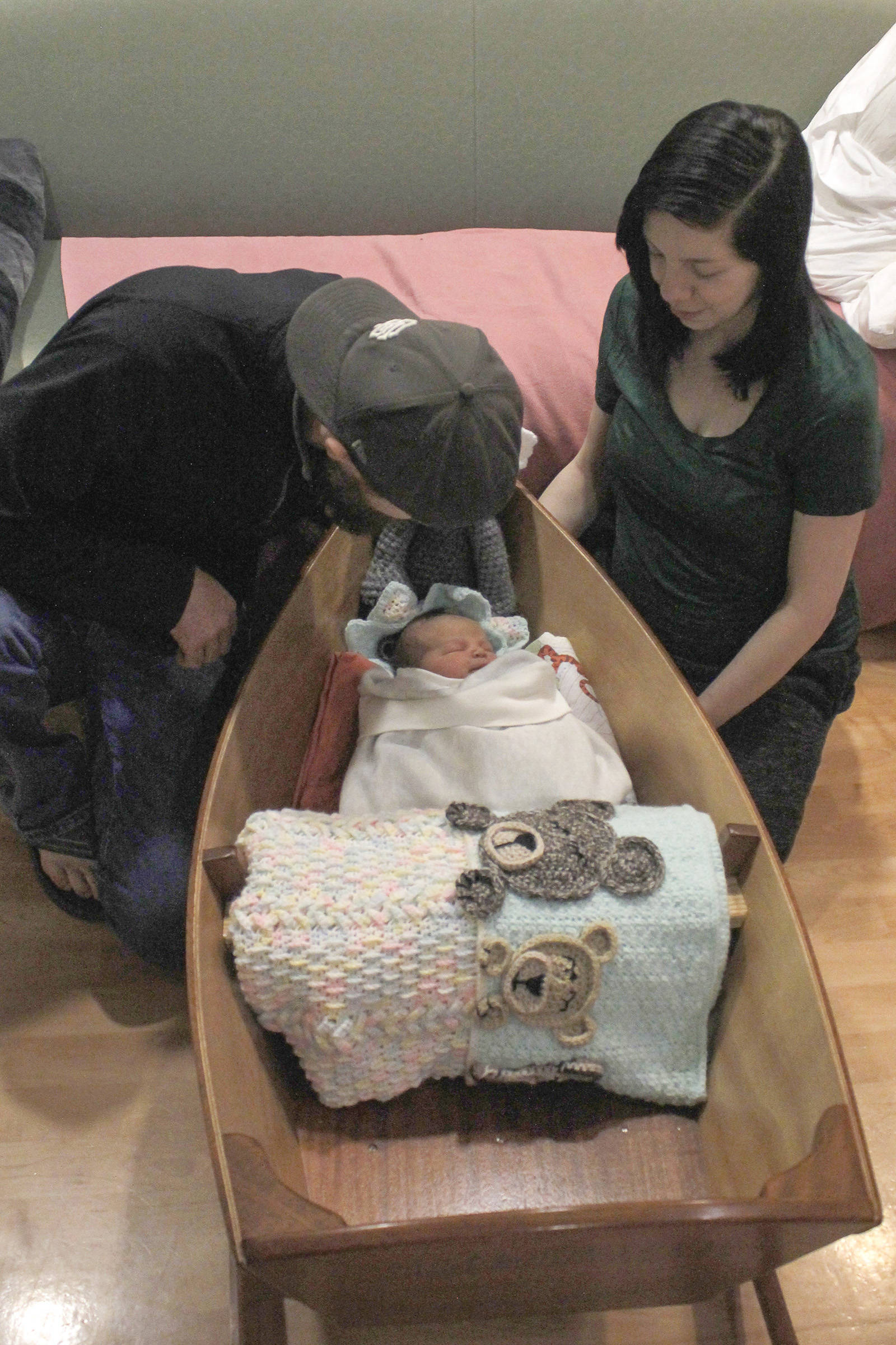 Yakutat residents Cody Kunau and Samantha Munoz sit with their baby Saige Roisin Kuneau on Friday, Jan. 4 at Bartlett Regional Hospital. Saige was the first baby born at the hospital this year, and received a boat carved by BRH Emergency Room Dr. Lindy Jones. (Alex McCarthy | Juneau Empire)