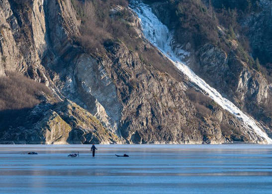 Biker Bob Funk is pictured after falling through the ice of Mendenhall Lake on Sunday. His grandson is pictured on the ice nearby. (Courtesy Photo | Carol Lahnum)