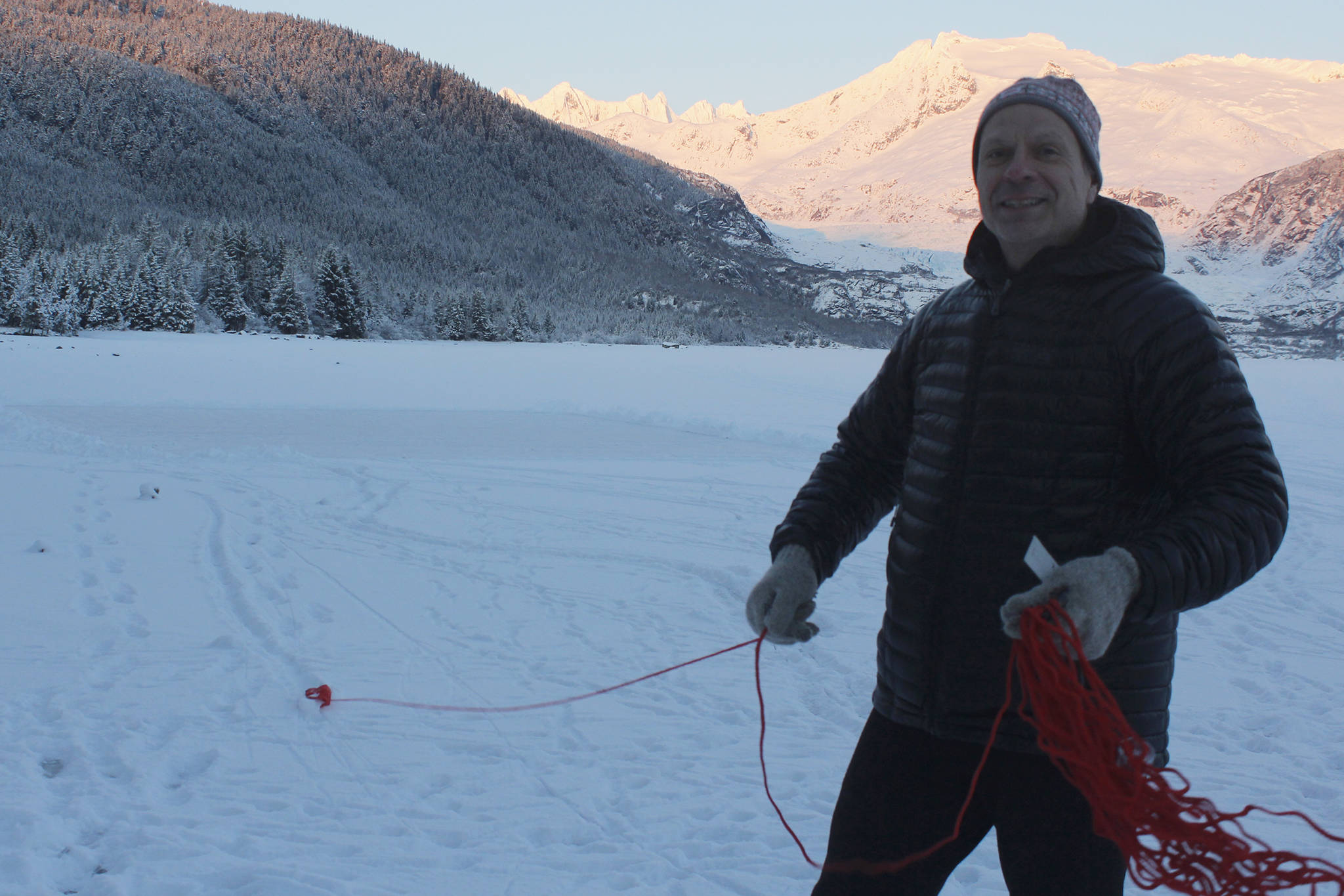 Scott McCutcheon demonstrates with a rescue rope on Tuesday after helping save Bob Funk, a biker who had fallen through the ice at Mendenhall Lake, a few days earlier. (Alex McCarthy | Juneau Empire)