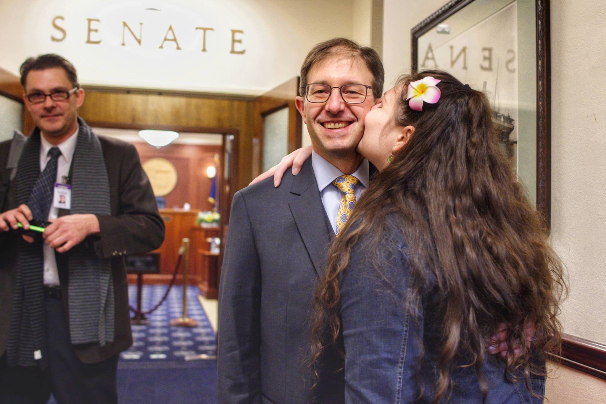 Sen. Jesse Kiehl, D-Juneau, receives a kiss from his daughter, Adara, before Kiehl is sworn in on the first day of the 31st Session of the Alaska Legislature on Tuesday, Jan. 15, 2019. (Michael Penn | Juneau Empire)