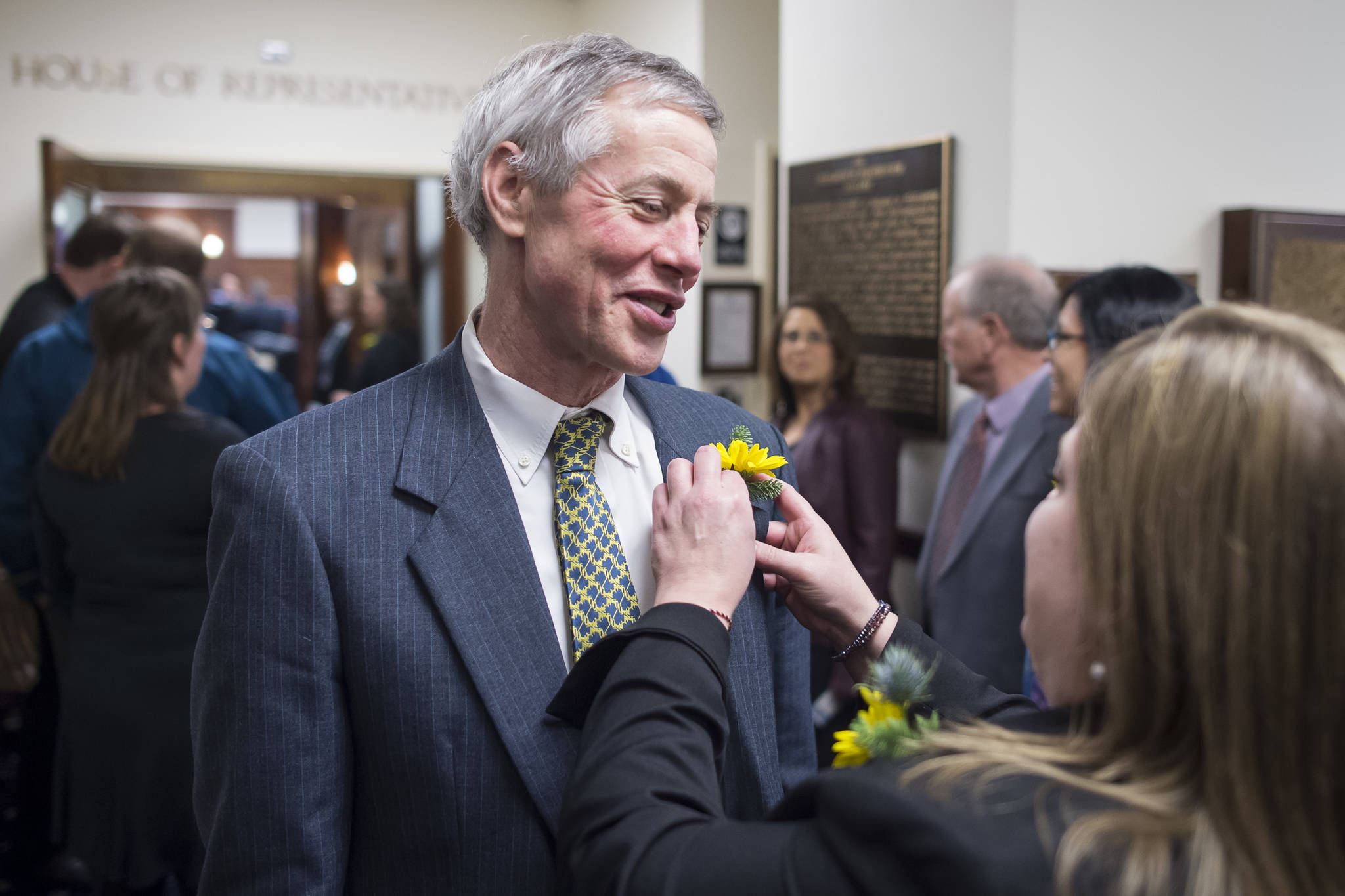 Rep. Geran Tarr, D-Anchorage, right, pins a flower for Rep. Matt Claman, D-Anchorage, on the opening day of the 31st Session of the Alaska Legislature on Tuesday, Jan. 15, 2019. (Michael Penn | Juneau Empire)