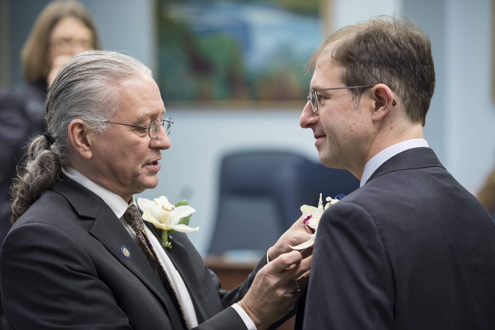 Sen. Tom Begich, D-Anchorage, left, pins a flower on incoming Sen. Jesse Kiehl, D-Juneau, on the opening day of the 31st Session of the Alaska Legislature on Tuesday, Jan. 15, 2019. (Michael Penn | Juneau Empire)