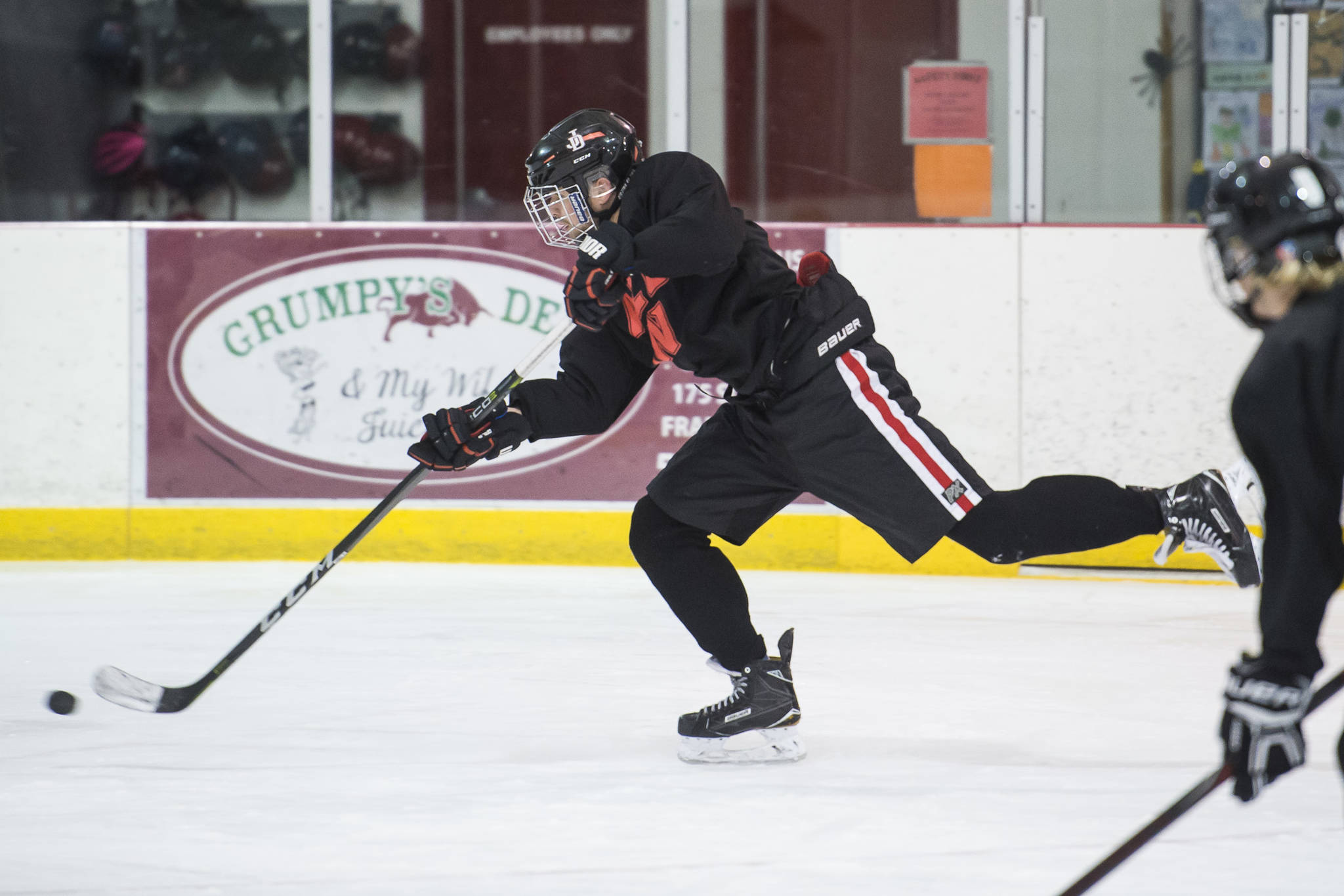 Senior Bill Bossse shoots to the goal during Juneau-Douglas High School hockey practice at Treadwell Arena on Thursday, Nov. 1, 2018. Bosse, who broke his jaw in a game earlier this season, leads the team with 14 goals and eight assists. (Michael Penn | Juneau Empire File)