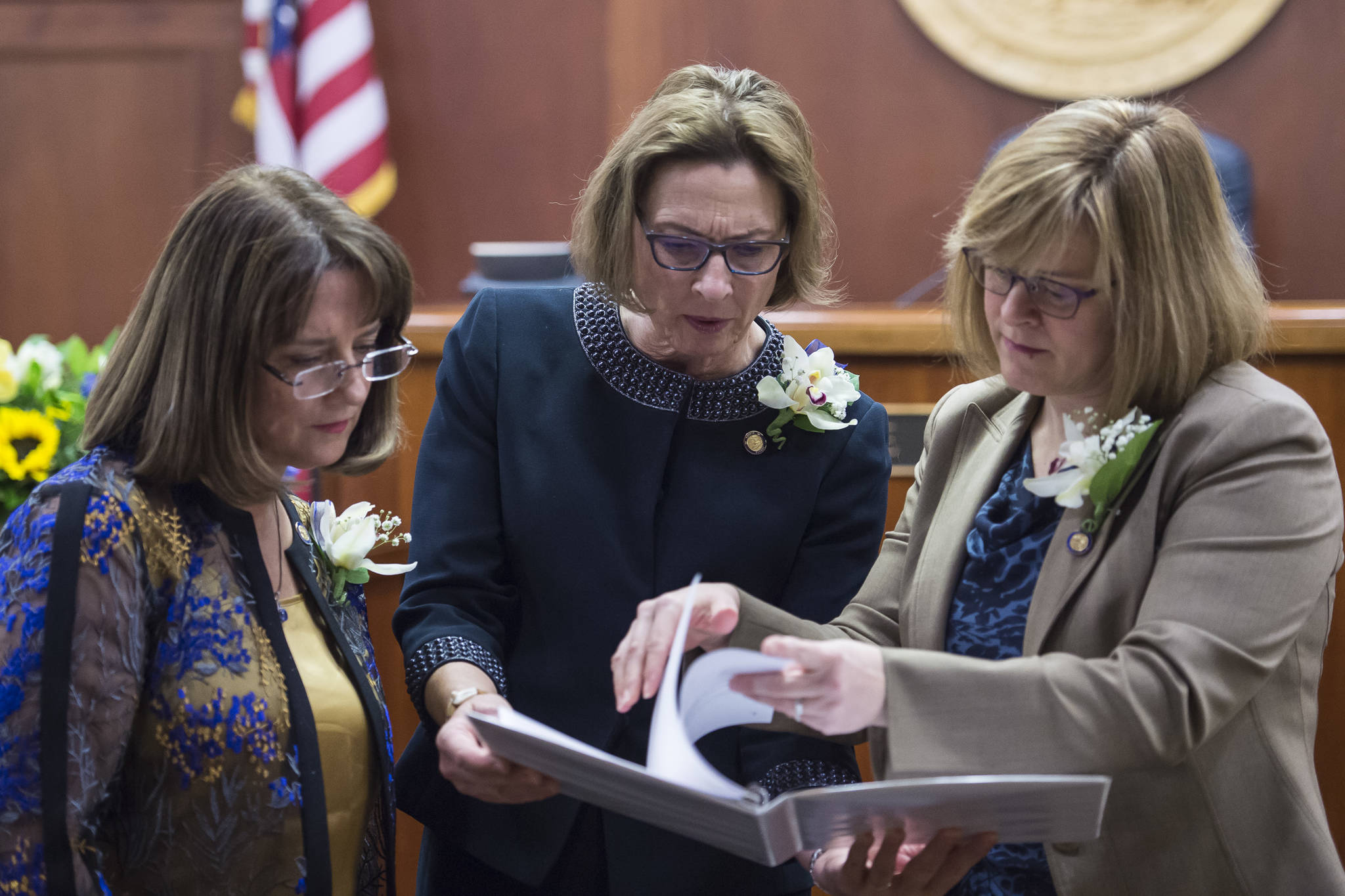 Sen. Lora Reinbold, R-Eagle River, left, Sen. President Cathy Giessel, R-Anchorage, center, and Majority Leader Sen. Mia Costello, R-Anchorage, study their play book on the opening day of the 31st Session of the Alaska Legislature on Tuesday, Jan. 15, 2019. (Michael Penn | Juneau Empire)