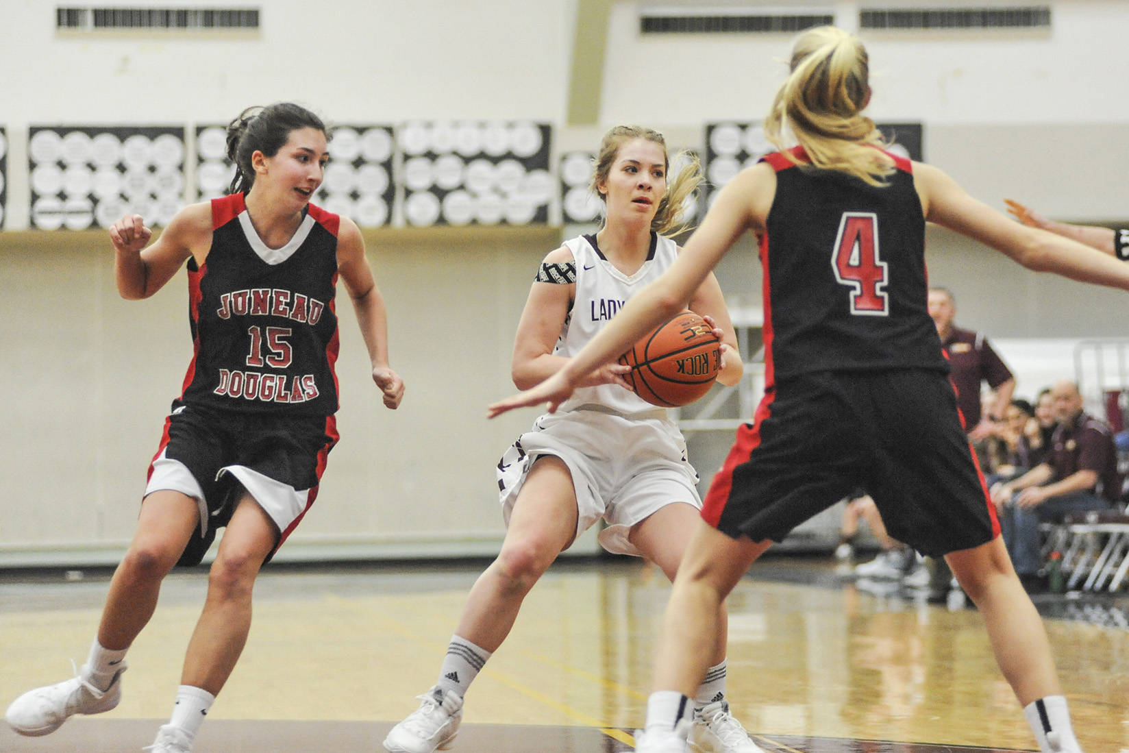Juneau-Douglas players Jenae Pusich, left and Sadie Tuckwood, right, put the pressure on Kayhi’s Ashley Hufine in the first quarter Friday night at the Clarke Cochrane Gymnasium. JDHS won 50-35 over the Lady Kings. (Hall Anderson | Ketchikan Daily News)