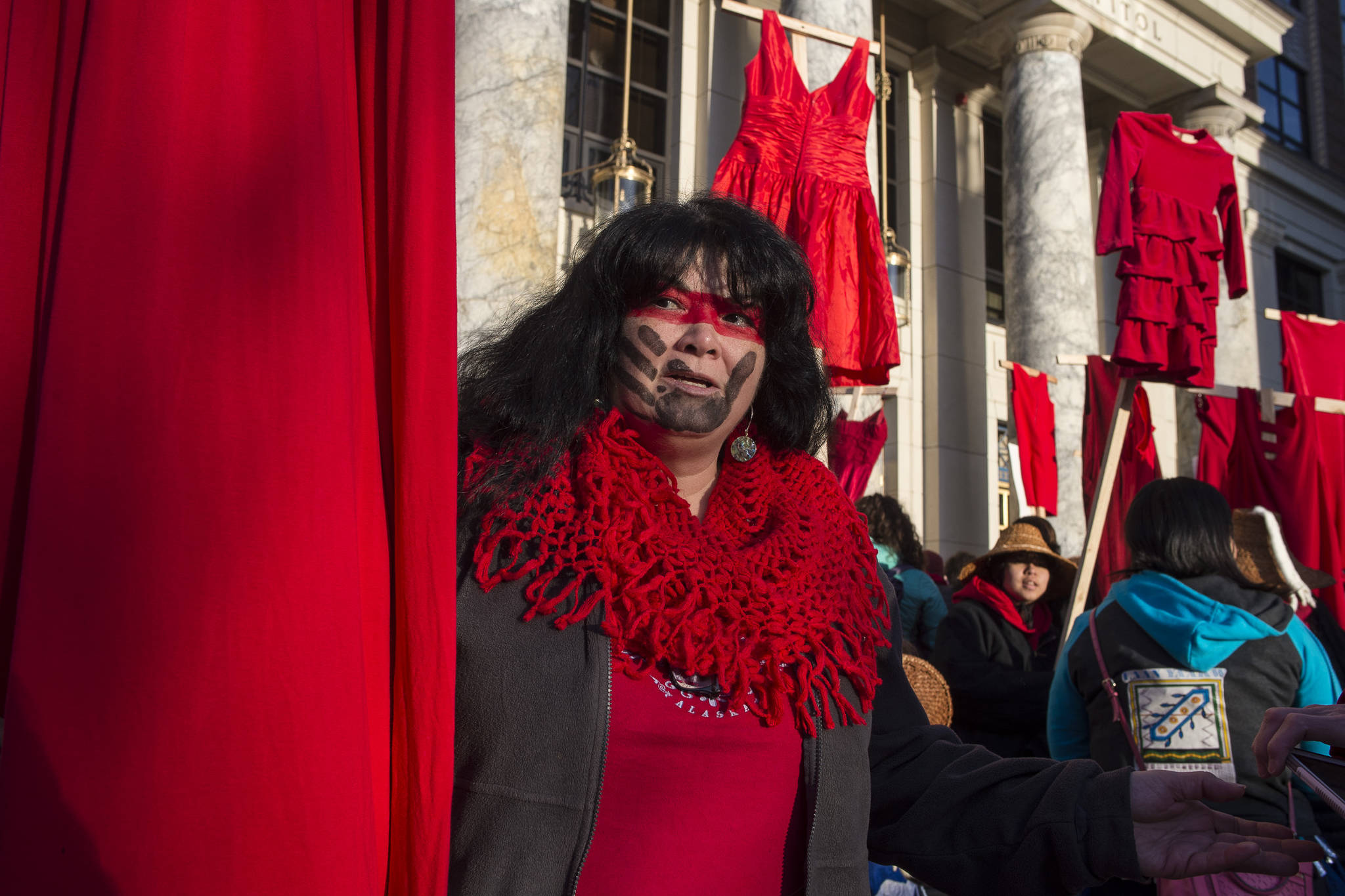 Susan Brouillette attends with Native women holding up red dresses to symbolize missing and murdered indigenous women during the Women’s March on Juneau in front of the Alaska State Capitol on Saturday, Jan. 19, 2019. (Michael Penn | Juneau Empire)