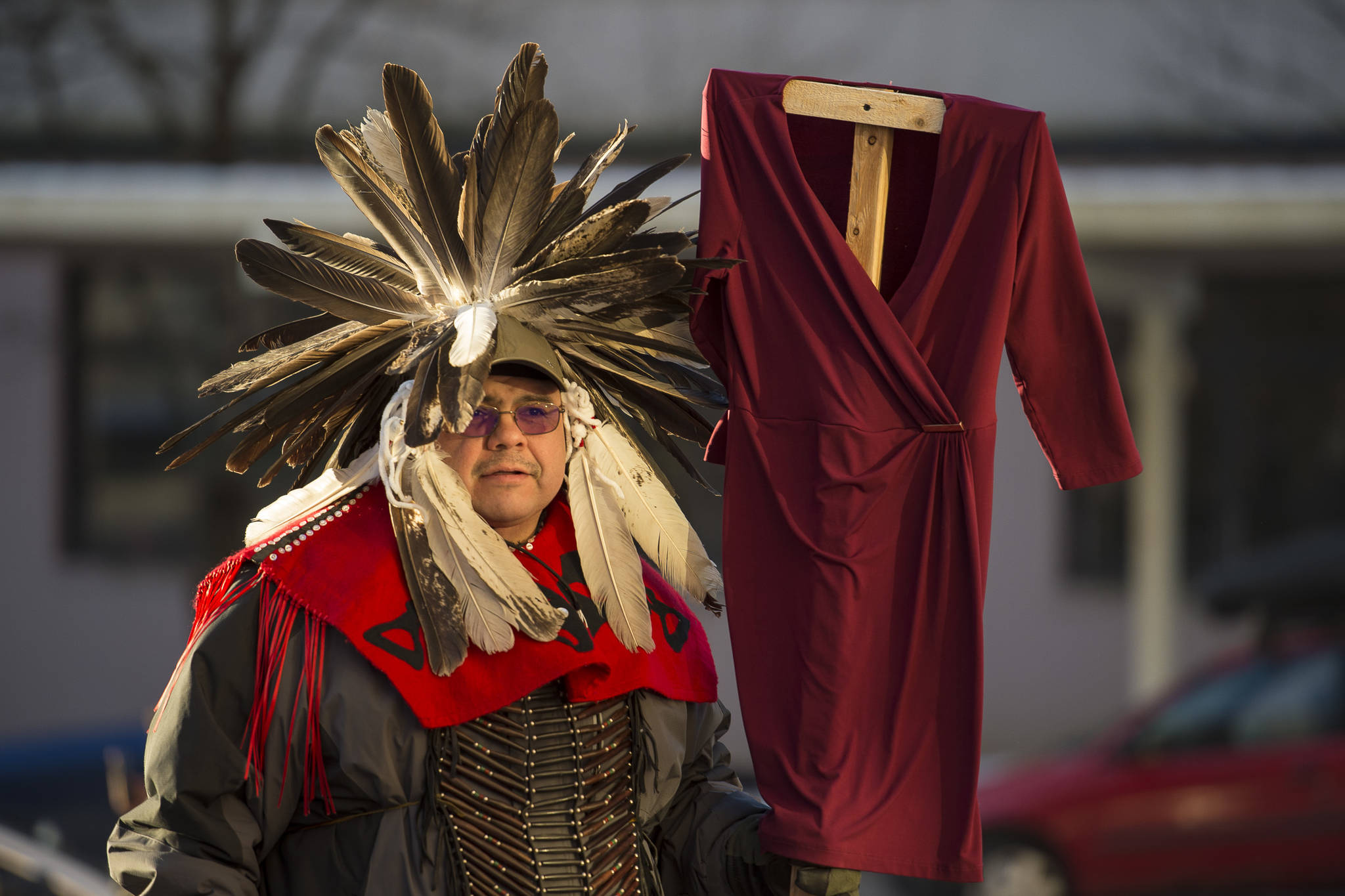 Justin McDonald attends with Native women holding up red dresses to symbolize missing and murdered indigenous women during the Women’s March on Juneau in front of the Alaska State Capitol on Saturday, Jan. 19, 2019. (Michael Penn | Juneau Empire)