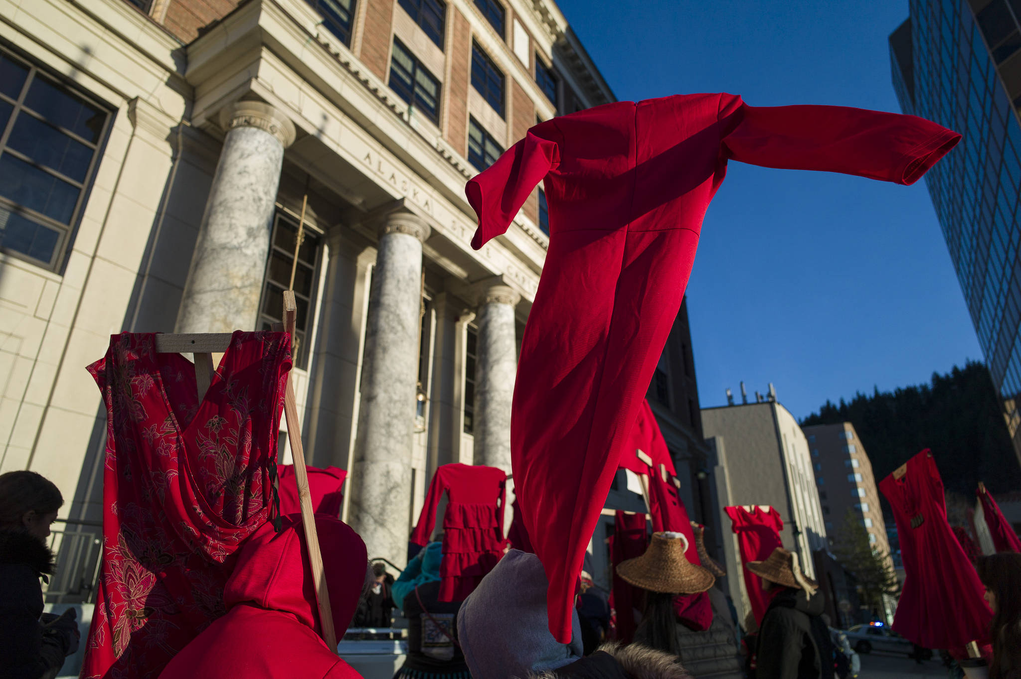 Native women hold up red dresses to symbolize missing and murdered indigenous women during the Women’s March on Juneau in front of the Alaska State Capitol on Saturday, Jan. 19, 2019. (Michael Penn | Juneau Empire)