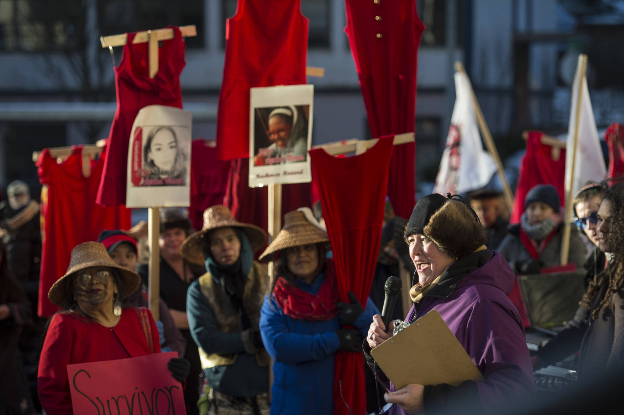 Rep. Sara Hannan speaks as Native women hold up red dresses to symbolizing missing and murdered indigenous women during the Women’s March on Juneau in front of the Alaska State Capitol on Saturday, Jan. 19, 2019. (Michael Penn | Juneau Empire)