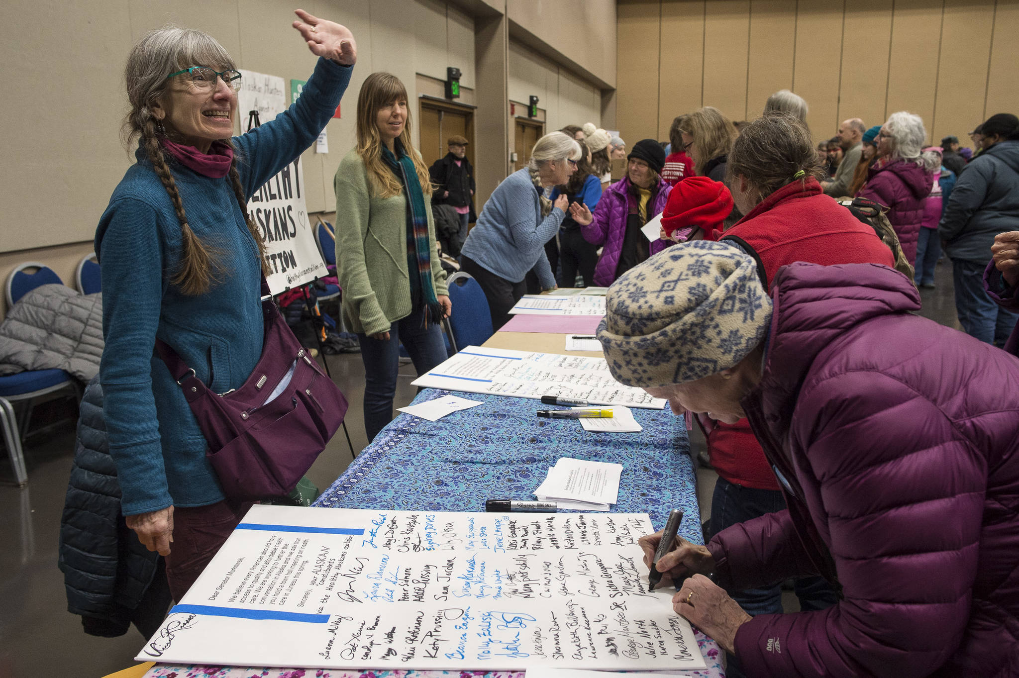 Luann McVey, left, and Julie Nielsen gather signatures for a universal health care letter to be sent to Sen. Lisa Murkowski after the Women’s March on Juneau at Centennial Hall on Saturday, Jan. 19, 2019. (Michael Penn | Juneau Empire)