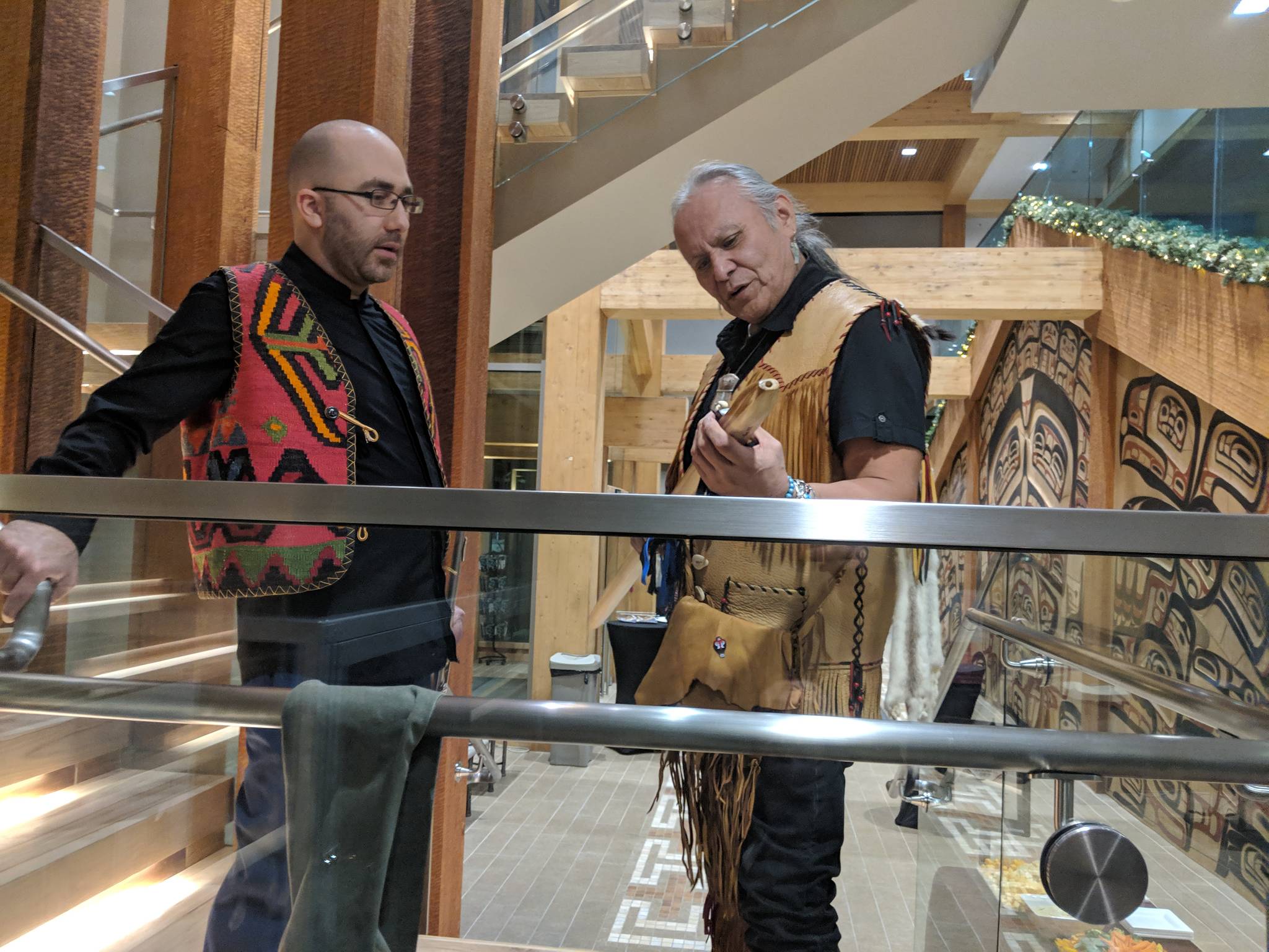 Tlingit flautist George Montero and Armenian flautist Tigran Arakelyan talk in the Walter Soboleff building before heading to the clan house that gave Shuká Hít Series: Flutes From Around the World concert its name, Saturday, Jan. 19, 2019. (Ben Hohenstatt | Capital City Weekly)