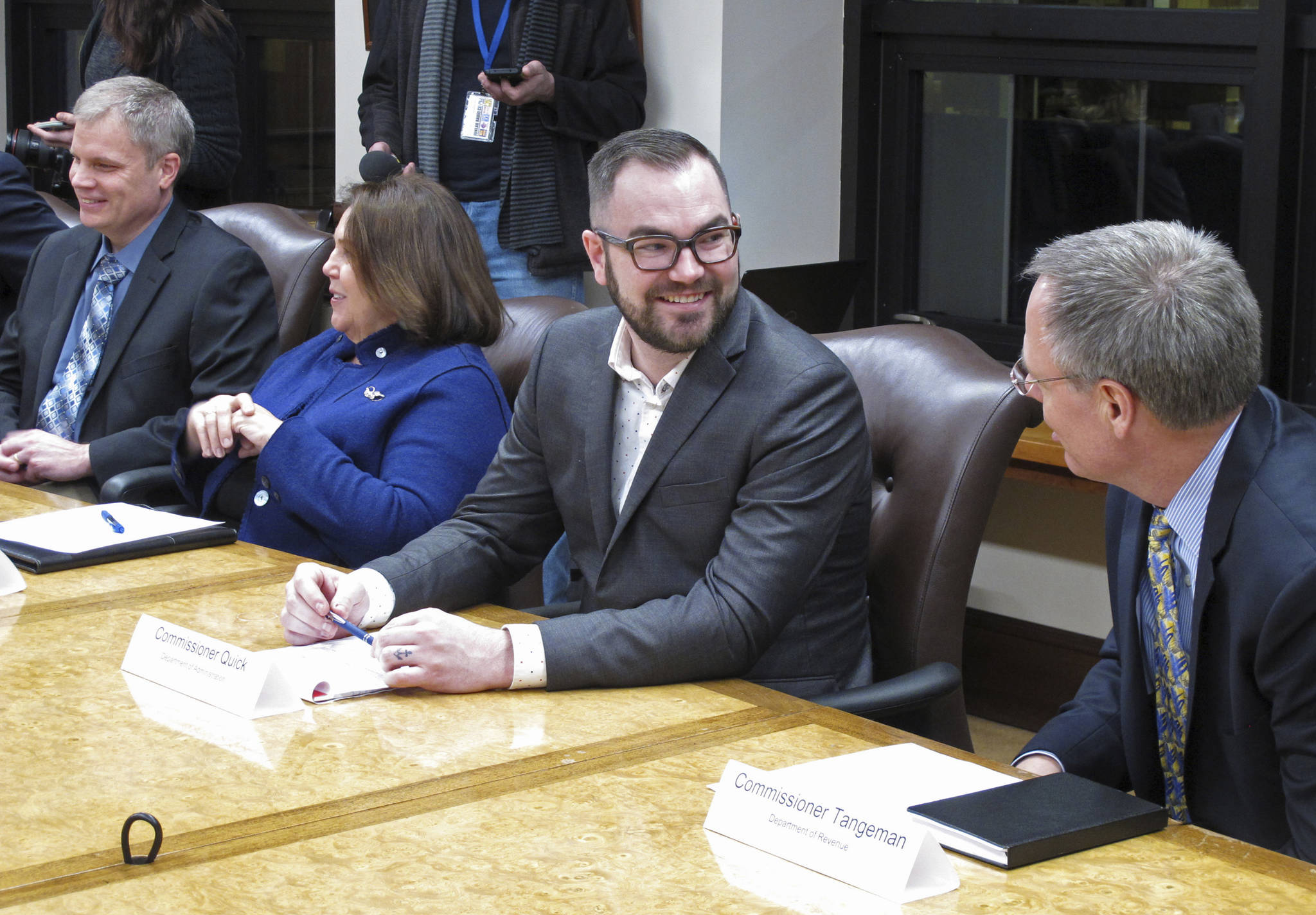 In this Jan. 8, 2019, file photo, Alaska Department of Administration Commissioner nominee Jonathan Quick, second from right, speaks with Revenue Commissioner Bruce Tangeman, right, before the start of a cabinet meeting at the state Capitol. Quick was accused of lying about his business background that he had an ownership interest in Anthem Coffee and Tea and Elements Frozen Yogurt. (AP Photo/Becky Bohrer, File)