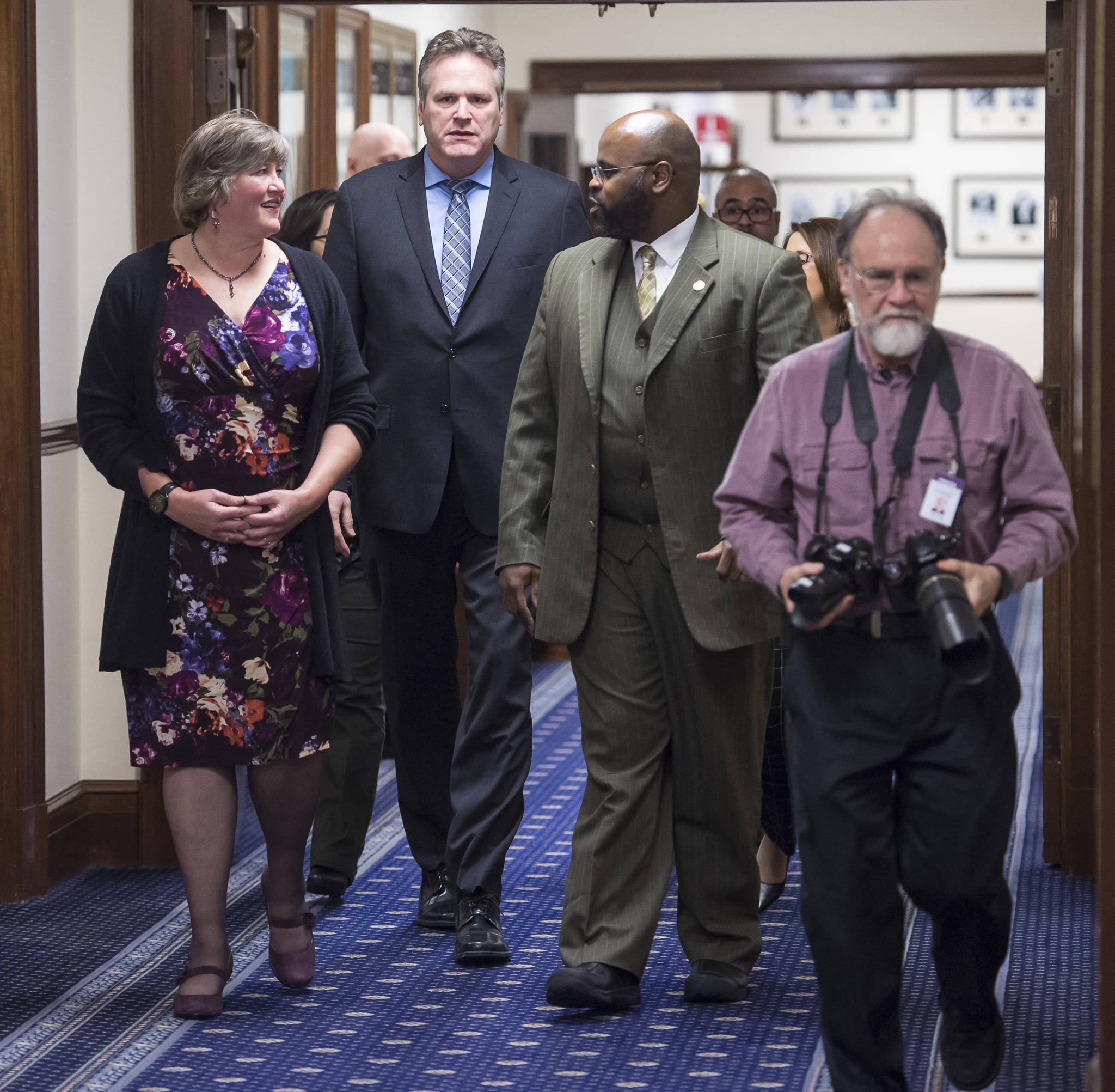 Gov. Mike Dunleavy is escorted to his State of the State speech in the House chamber at the Capitol in Juneau, Alaska, by Rep. Sara Hannan, D-Juneau, left, and Sen. David Wilson, R-Wasilla, (and Gavel Alaska’s Skip Gray, right) to a Joint Session of the Alaska Legislature on Tuesday, Jan. 22, 2019. (Michael Penn | Juneau Empire)