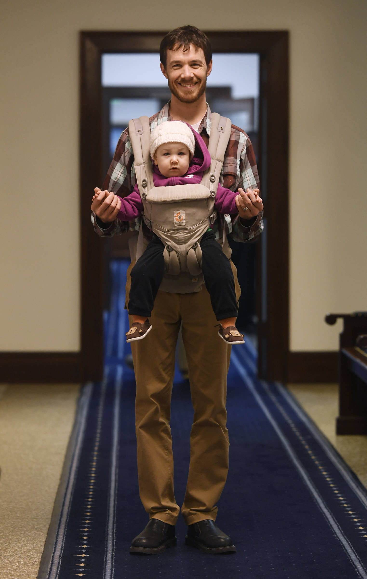Rep. Zack Fields, D-Anchorage, carries his 14-month-old daughter, Zara, along with him as he works at the Capitol on Tuesday, Feb. 5, 2019. (Michael Penn | Juneau Empire)