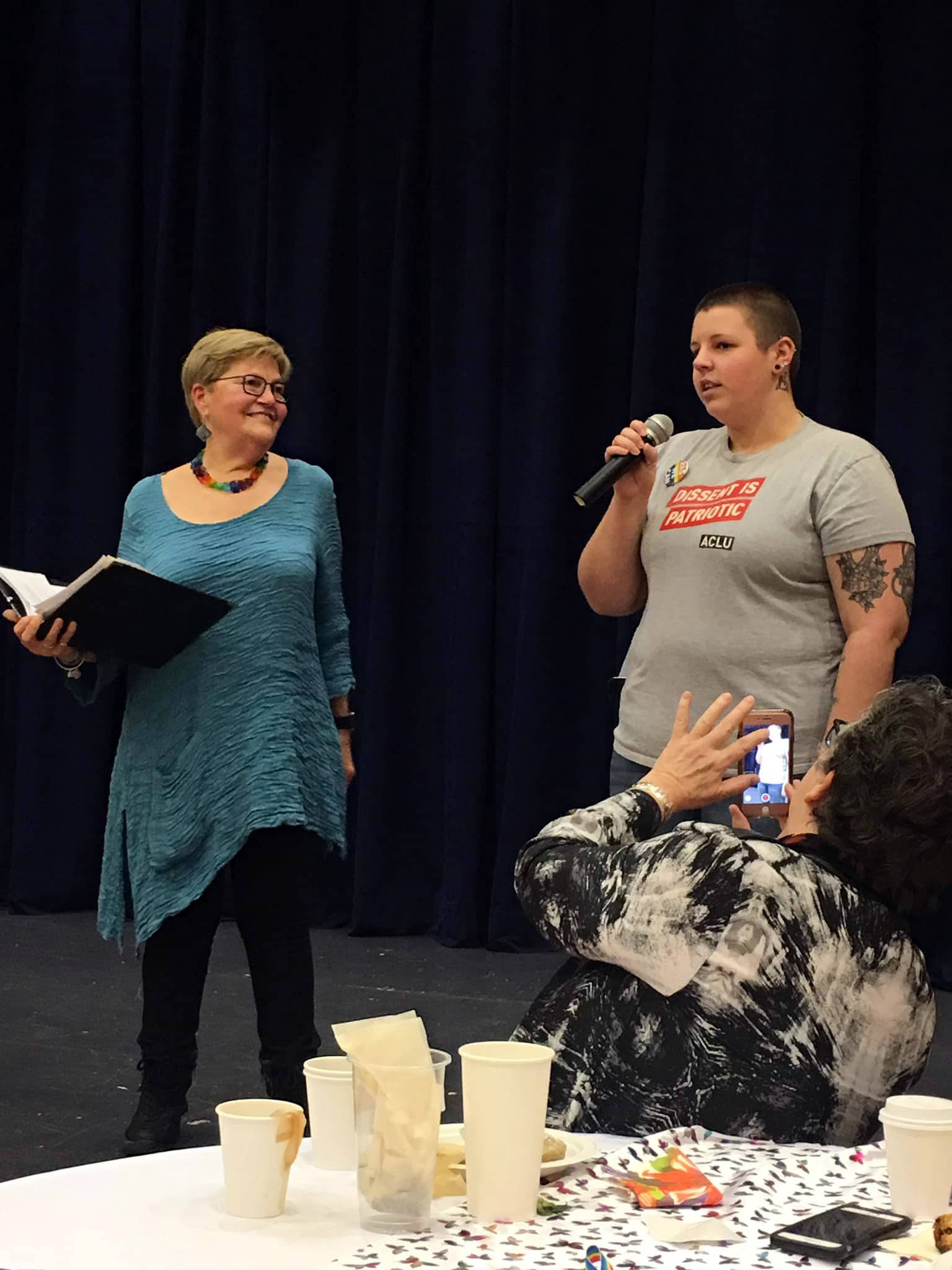 Stonewall 50 co-coordinators Maureen Longworth, left, and Tayler Shae, right, talk onstage during the Stonewall;; 50 Tea & Dance event Saturday, Feb. 9, 2019. (Courtesy Photo | For Stonewall 50 Project)