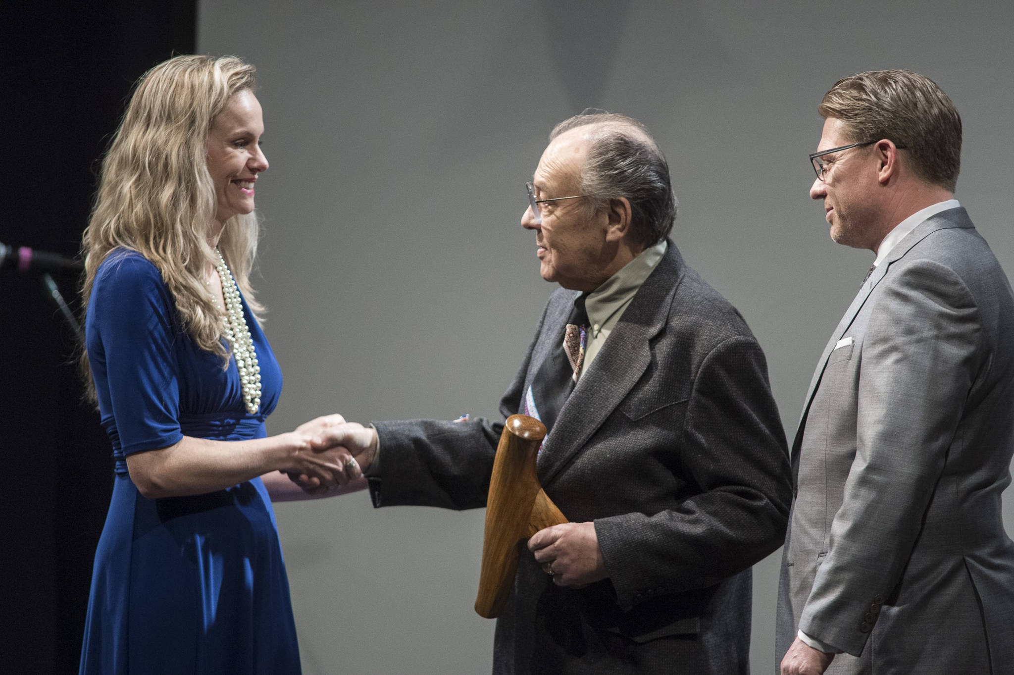 Jack Hudson, center, and his son, John Hudson III, of Metlakatla, receive their Alaska Native Arts Award from Kelly Tshibaka, Commissioner of the Department of Administration, at the 2019 Governor’s Arts and Humanities Awards at the Juneau Arts & Culture Center on Thursday, Feb. 7, 2019. (Michael Penn | Juneau Empire)
