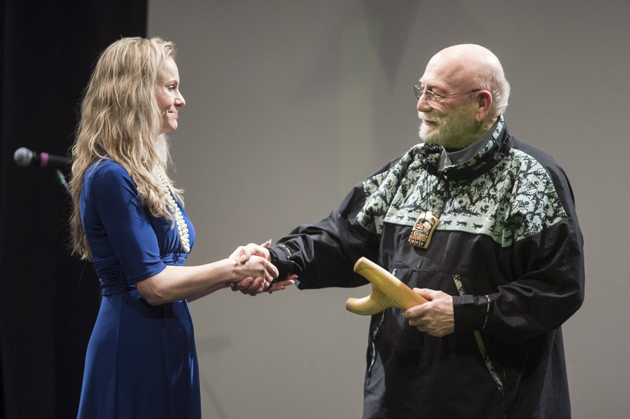Jon Van Zyle, of Eagle River, receives his Individual Artist Award from Kelly Tshibaka, Commissioner of the Department of Administration, at the 2019 Governor’s Arts and Humanities Awards at the Juneau Arts & Culture Center on Thursday, Feb. 7, 2019. (Michael Penn | Juneau Empire)