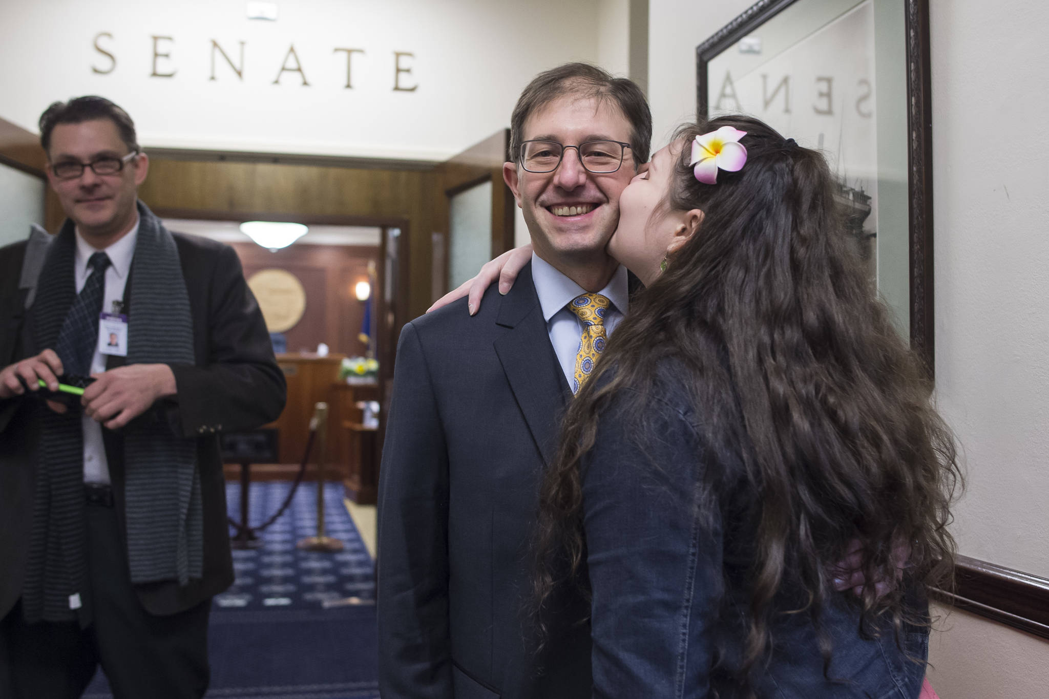Sen. Jesse Kiehl, D-Juneau, receives a kiss from his daughter, Adara, before Kiehl is sworn in on the first day of the 31st Session of the Alaska Legislature on Tuesday, Jan. 15, 2019. (Michael Penn | Juneau Empire)