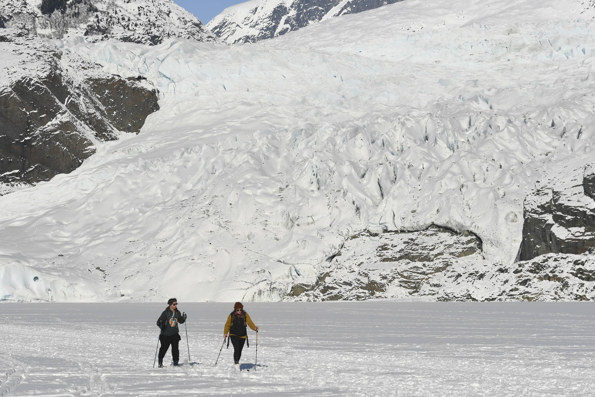 Sam Post, left, and Lydia Steele ski back from a visit to the Mendenhall Glacier on Monday, Feb. 11, 2019. (Michael Penn | Juneau Empire)