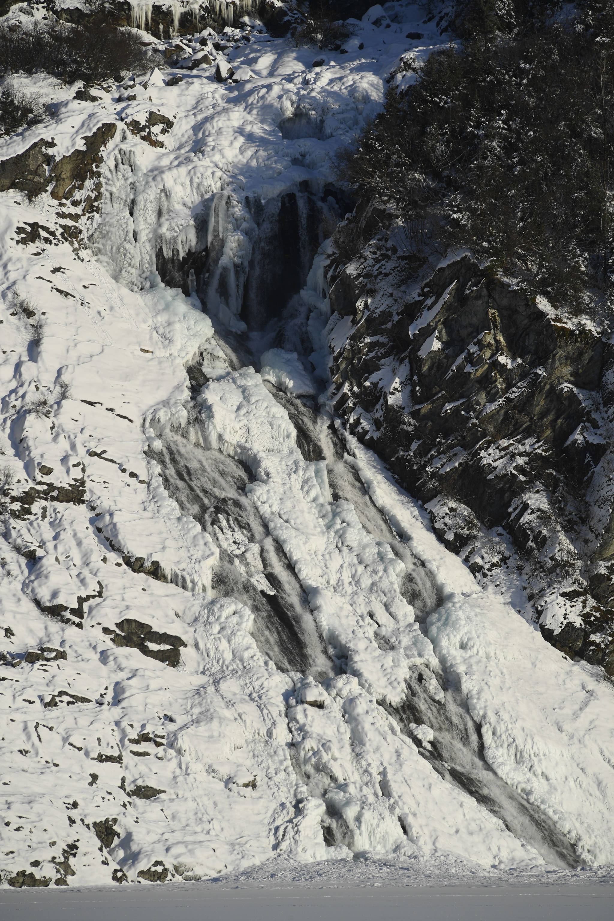 The frozen Nugget Falls flows into Mendenhall Lake on Monday, Feb. 11, 2019. (Michael Penn | Juneau Empire)