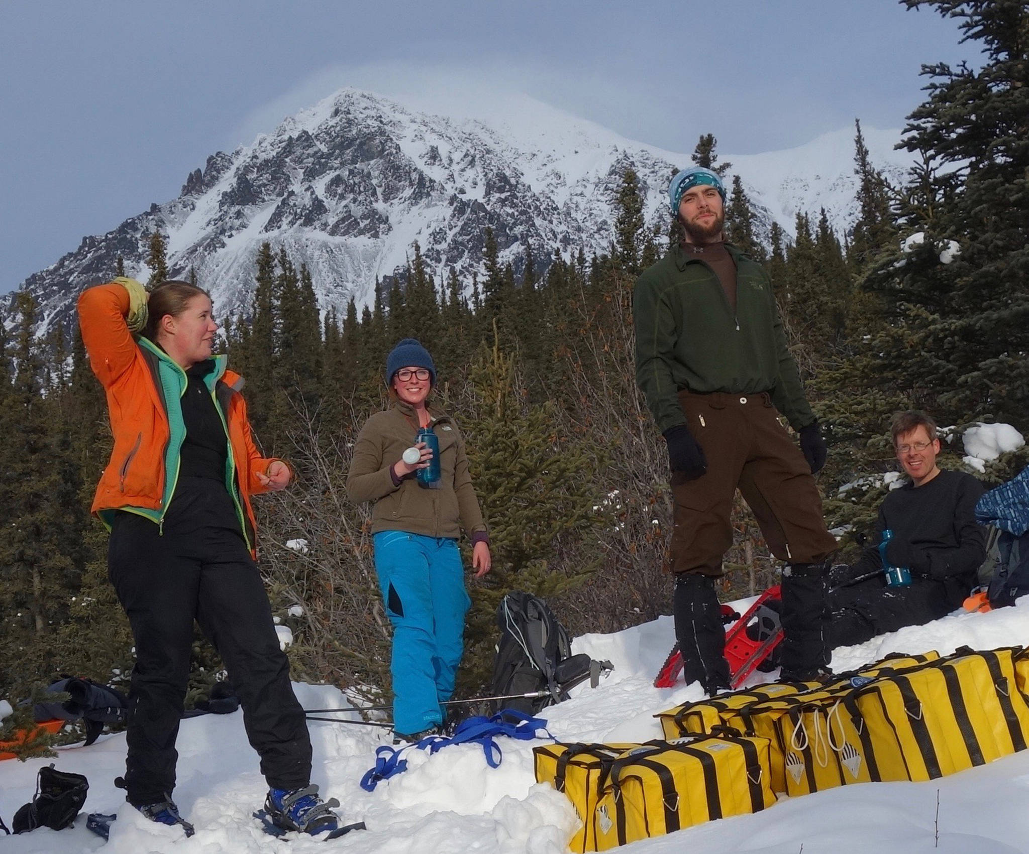 With Panorama Mountain in the background, from left, Lynn Kaluzienski, Elizabeth Berg, Cole Richards and Carl Tape take a break from stomping out a 1-kilometer snowshoe line across the Denali Fault near Cantwell. (Ned Rozell | For the Juneau Empire)