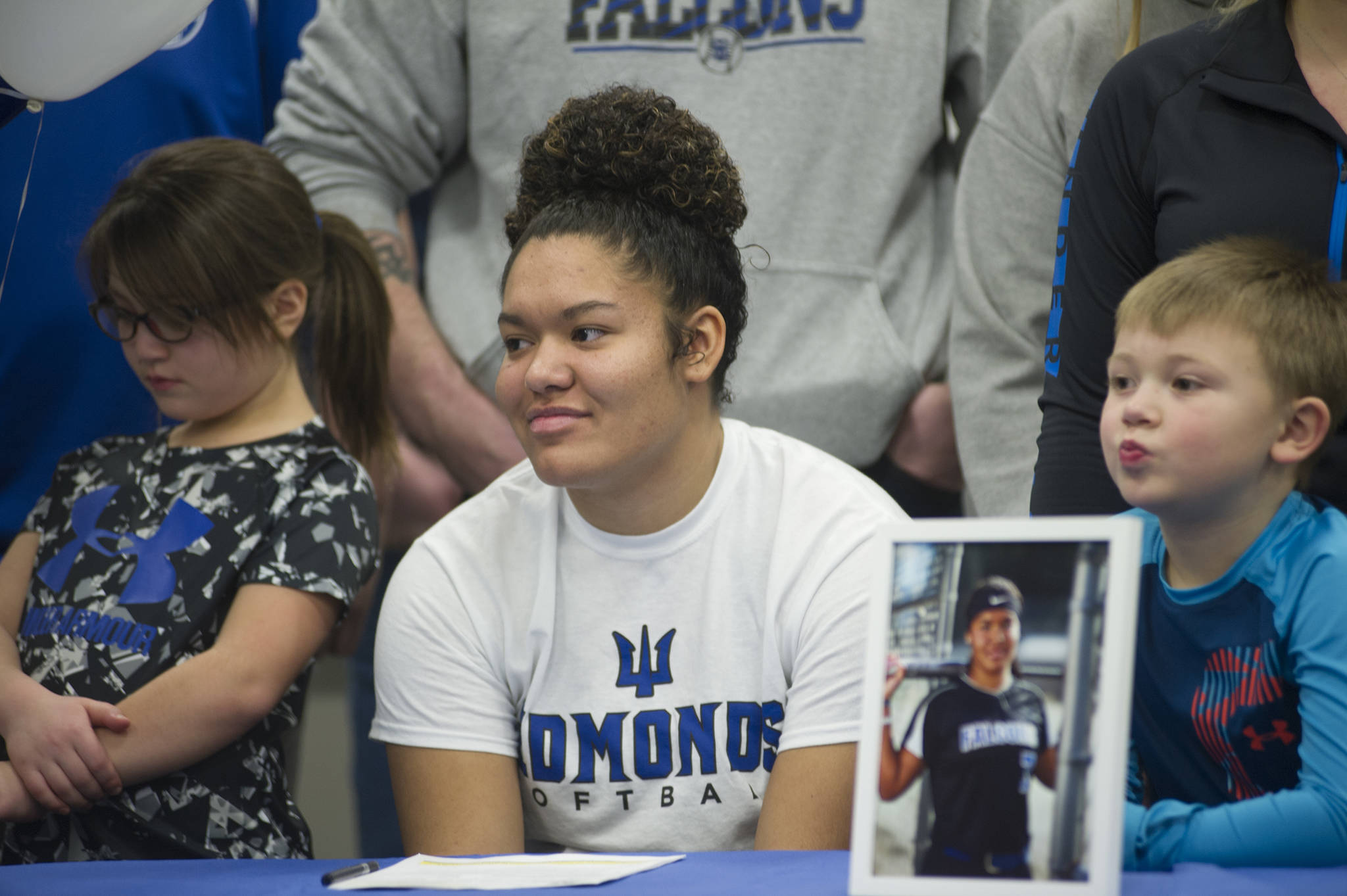 Thunder Mountain High School senior Kyra Jenkins Hayes listens to high school coach John Boucher’s comments before signing her letter of intent with Edmonds Community College on Sunday, Feb. 17, 2019, at TMHS. Standing next to Jenkins Hayes is sister Lily Hayes, left, and brother Eli Hayes. (Nolin Ainsworth | Juneau Empire)